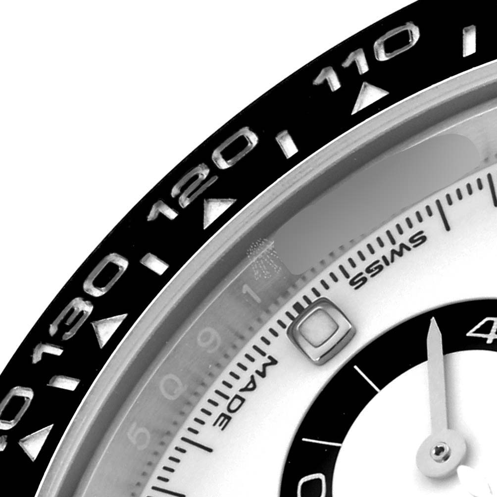 The image shows a close-up of the bezel and part of the dial of a Rolex Daytona 116500LN Men's Stainless Steel White Dial 116500LN Men's Stainless Steel White Dial watch, highlighting the tachymetric scale.