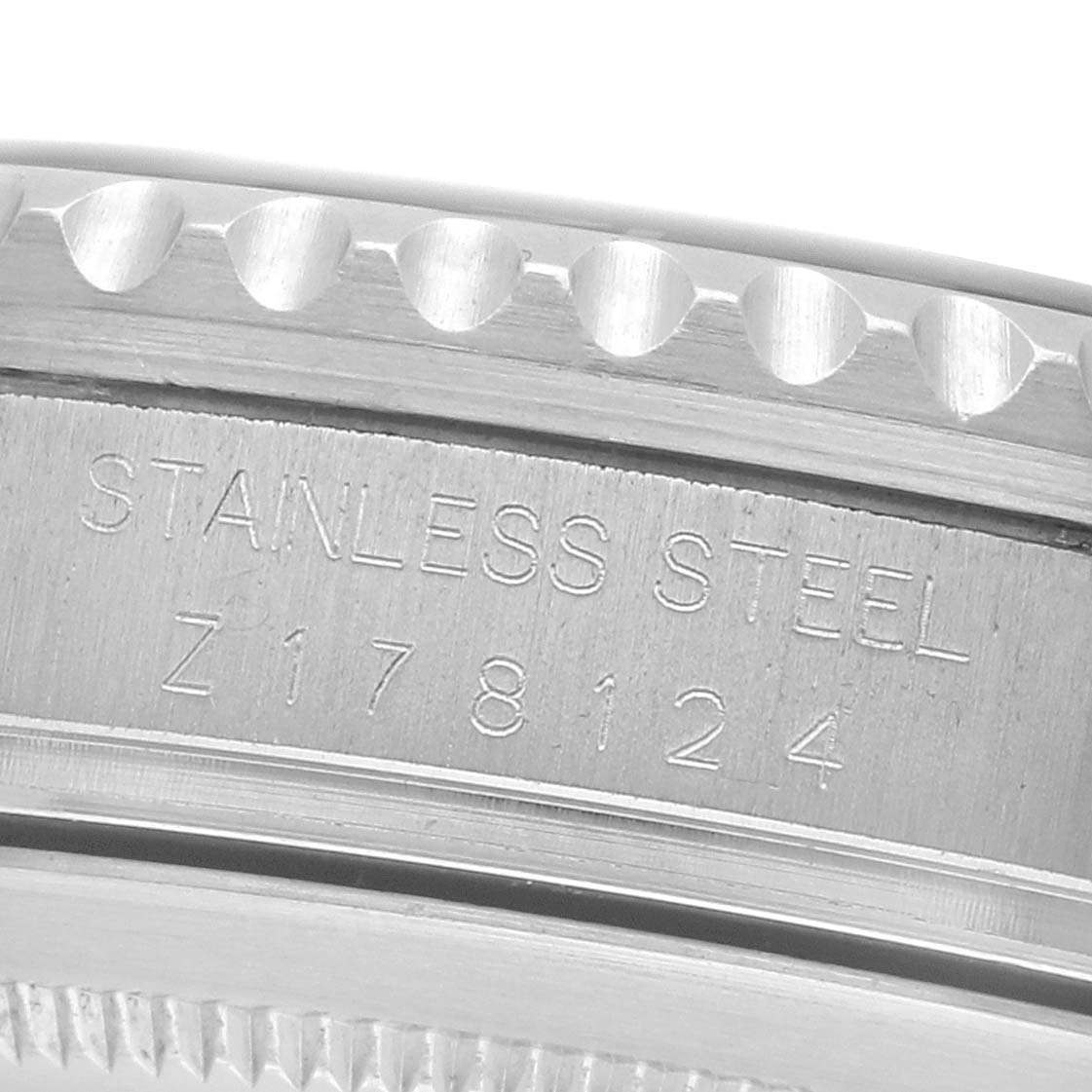 The image shows a close-up of the side of a Rolex GMT-Master 16710 Men's Stainless Steel Black Dial, focusing on the stainless steel bezel and engraved serial number.