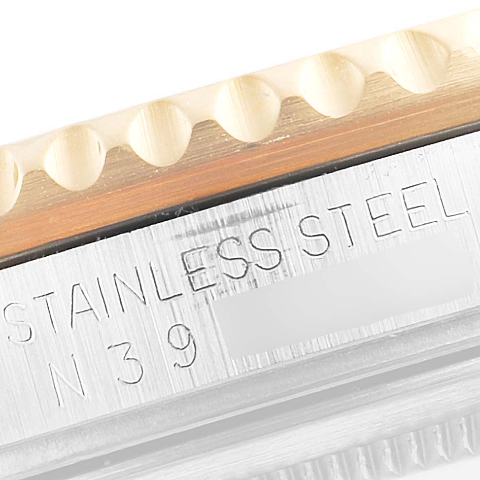 This close-up image shows the engraved "STAINLESS STEEL" marking and part of the bezel of a Rolex GMT-Master 16713 Men's Steel and Gold (two tone) Black Dial 16713 Men's Steel and Gold (two tone) Black Dial watch.