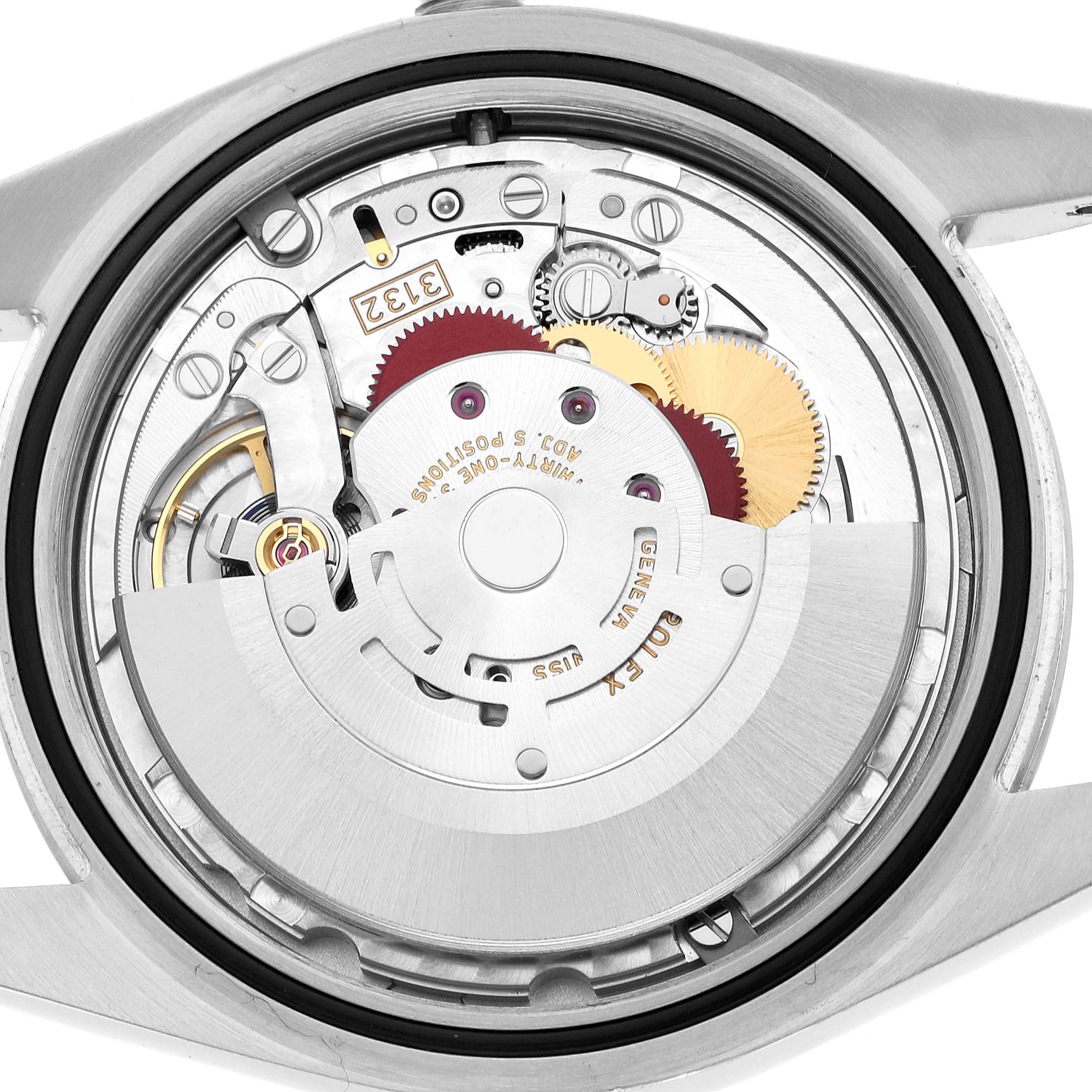 The image shows the Rolex Oyster Perpetual 114300 Men's Stainless Steel Purple Dial movement from the back, highlighting gears and the rotor mechanism.