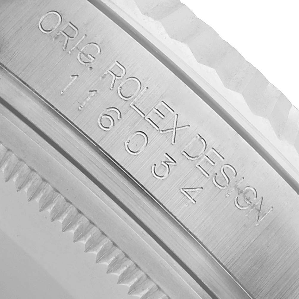 The image shows a close-up of the Rolex Oyster Perpetual 116034 Men's Stainless Steel Pink Dial model's bezel and the engraved "Orig Rolex Design" text.