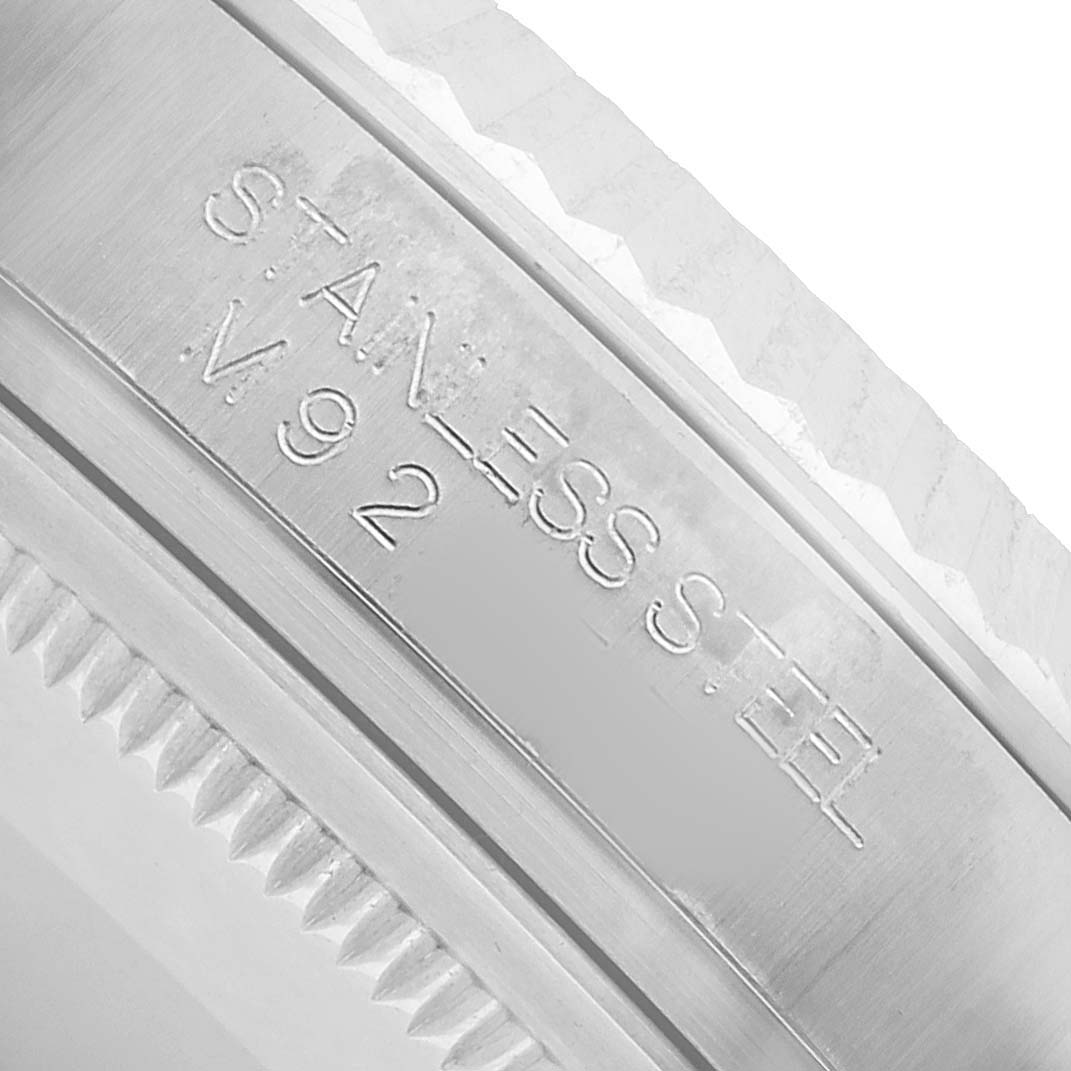 The image shows a close-up of the case back edge of a Rolex Oyster Perpetual 116034 Men's Stainless Steel Pink Dial, highlighting the "STAINLESS STEEL" engraving.