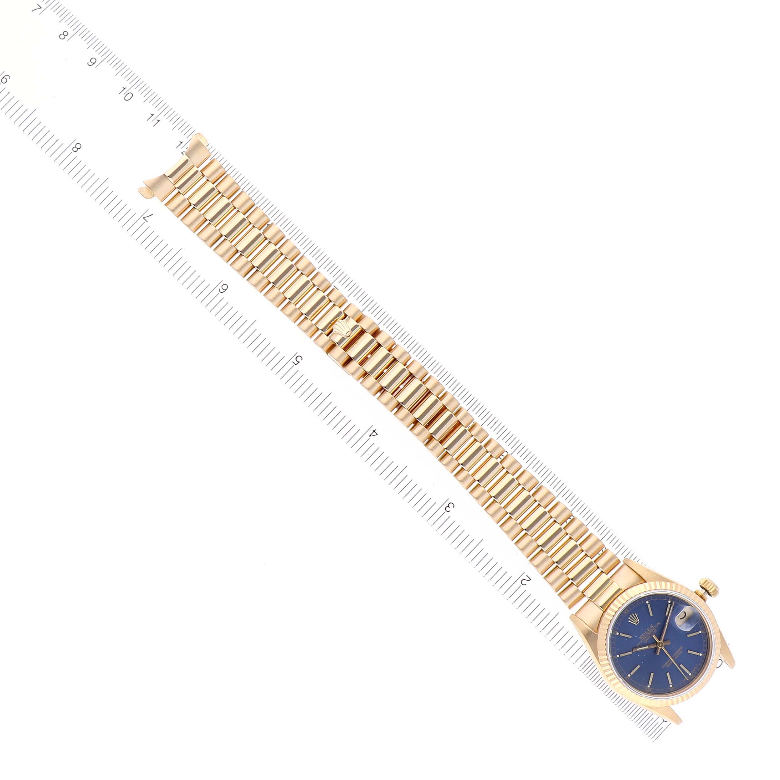 The Rolex President 68278 Women's Yellow Gold Blue Dial 68278 Women's Yellow Gold Blue Dial watch is shown from a top view, featuring its gold band and blue dial, alongside a ruler for scale.
