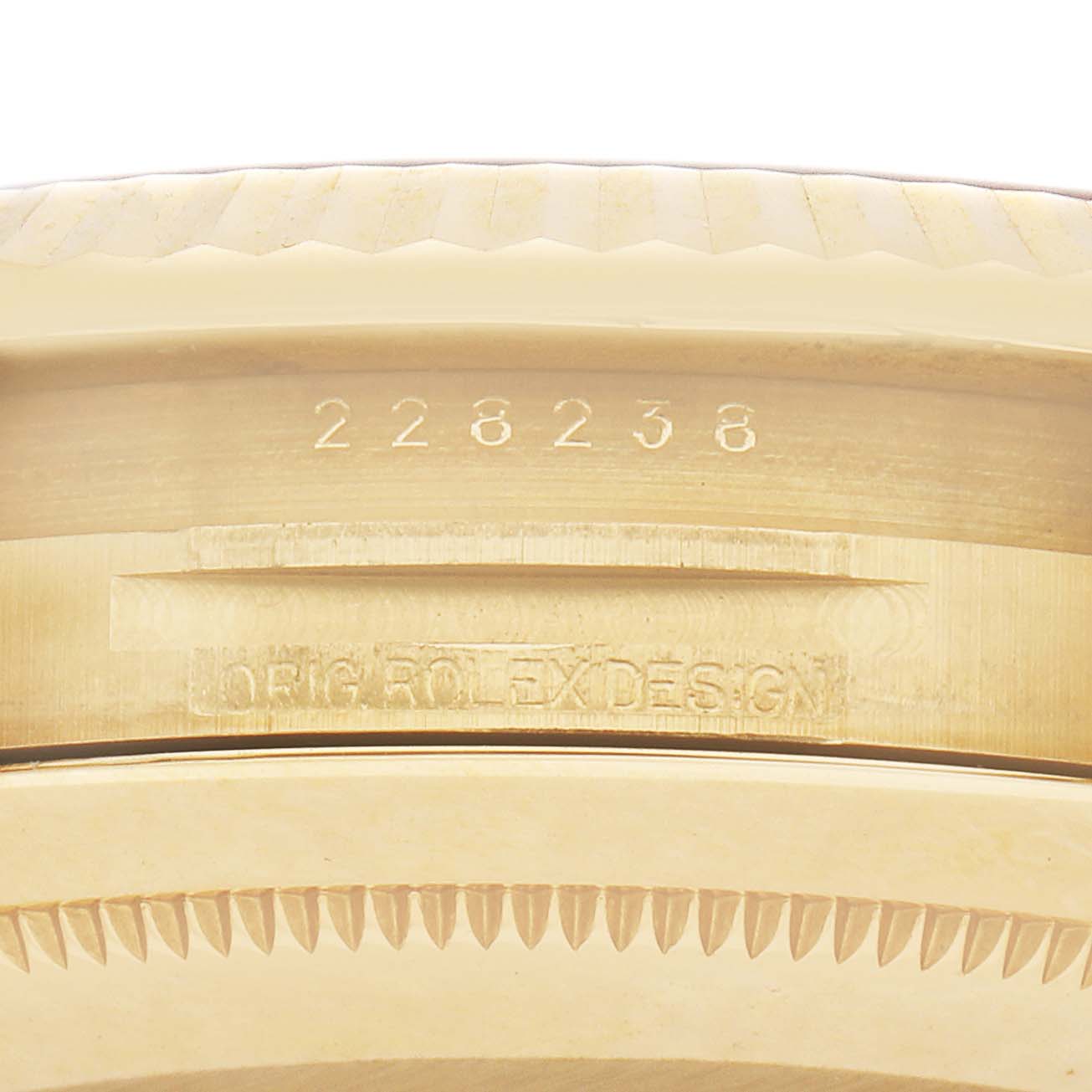 This image shows the side view of a Rolex President 228238 Men's Yellow Gold Champagne Dial model's case with serial and design engravings.