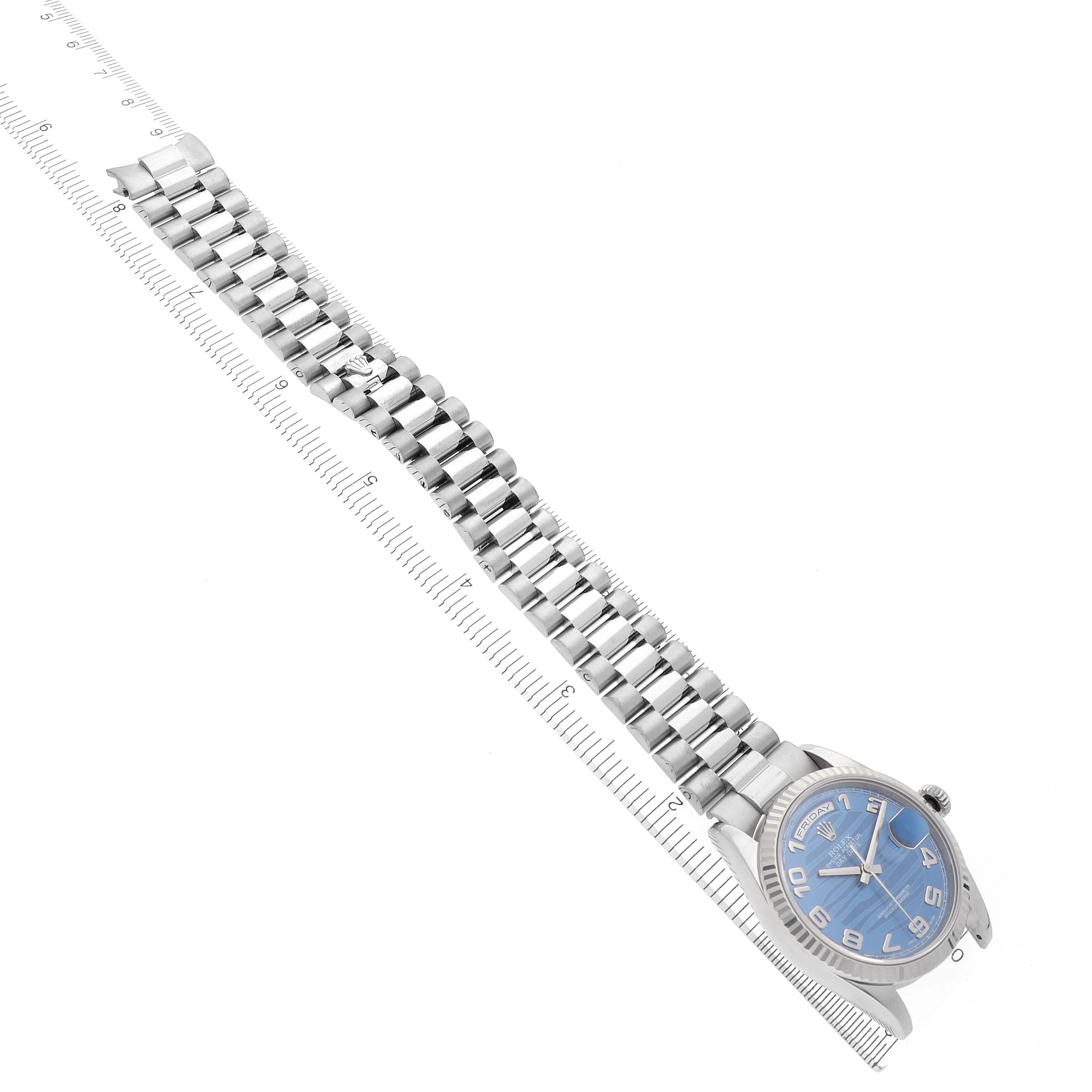 The image shows a Rolex President 118239 Men's White Gold Blue Dial 118239 Men's White Gold Blue Dial model watch in a top-down angle, highlighting the face and full bracelet beside a ruler.