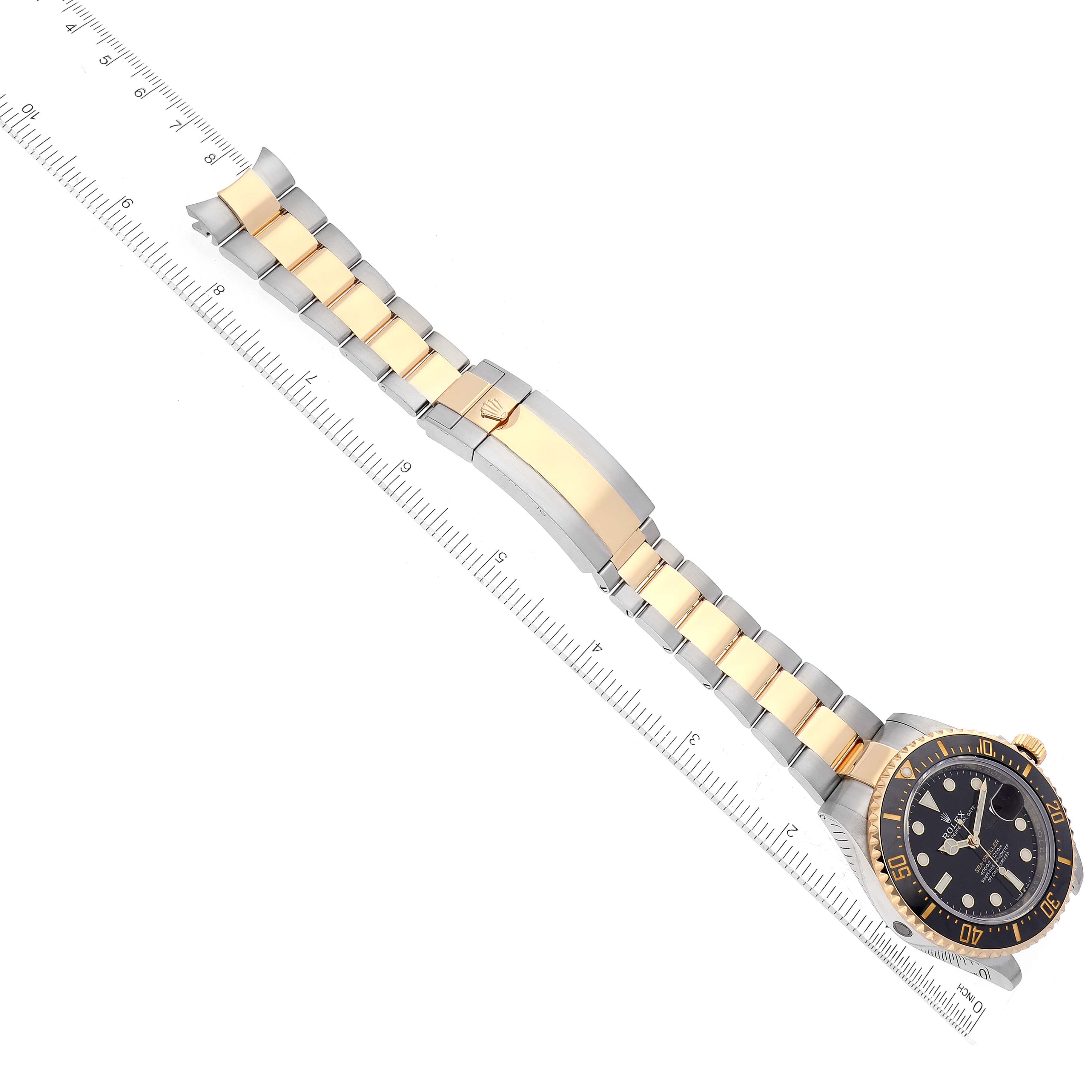 The image shows the face and bracelet of the Rolex Sea-Dweller 126603 Men's Steel and Gold (two tone) Black Dial 126603 Men's Steel and Gold (two tone) Black Dial watch aligned with a ruler.