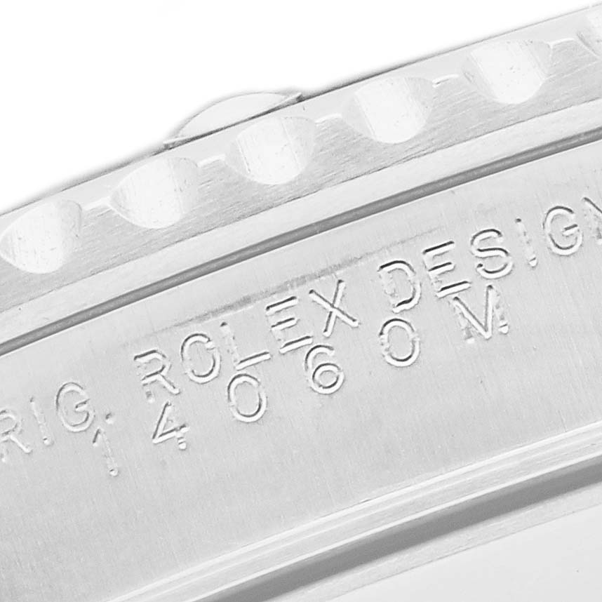 The image shows a close-up of the case side of a Rolex Submariner 14060 Men's Stainless Steel Black Dial, highlighting the model number and "Rolex Design" engraving.