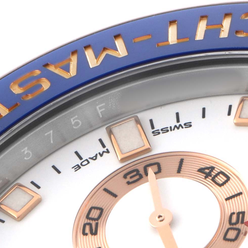 The image shows a close-up of the Rolex Yacht-Master 116681M Men's Steel and Gold (two tone) White Dial's bezel, dial, and part of the minute hand.