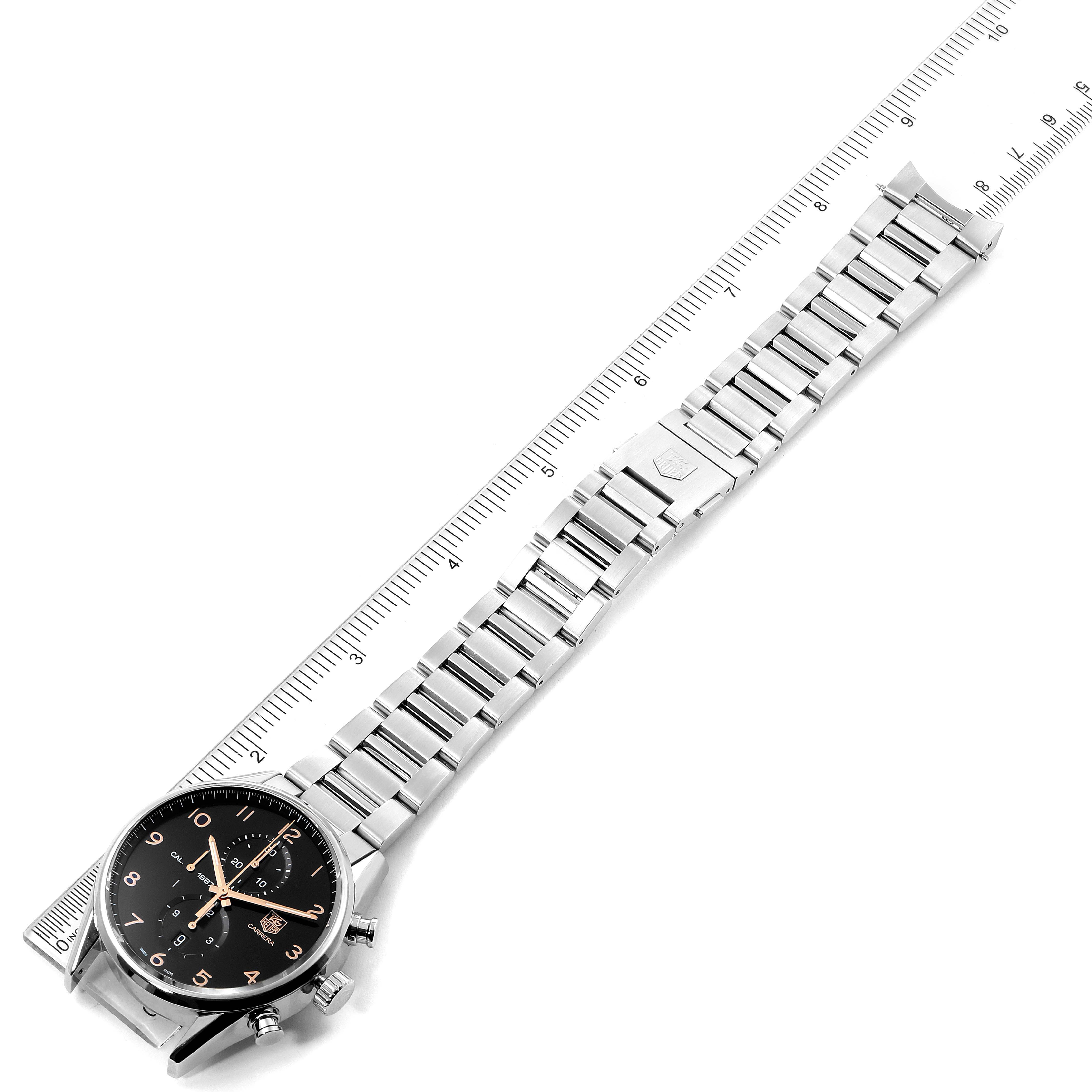 The image shows a Tag Heuer Carrera CAR2014.BA0796 Men's Stainless Steel Black Dial CAR2014.BA0796 Men's Stainless Steel Black Dial watch placed on a measuring scale, displaying its face and full metal band.