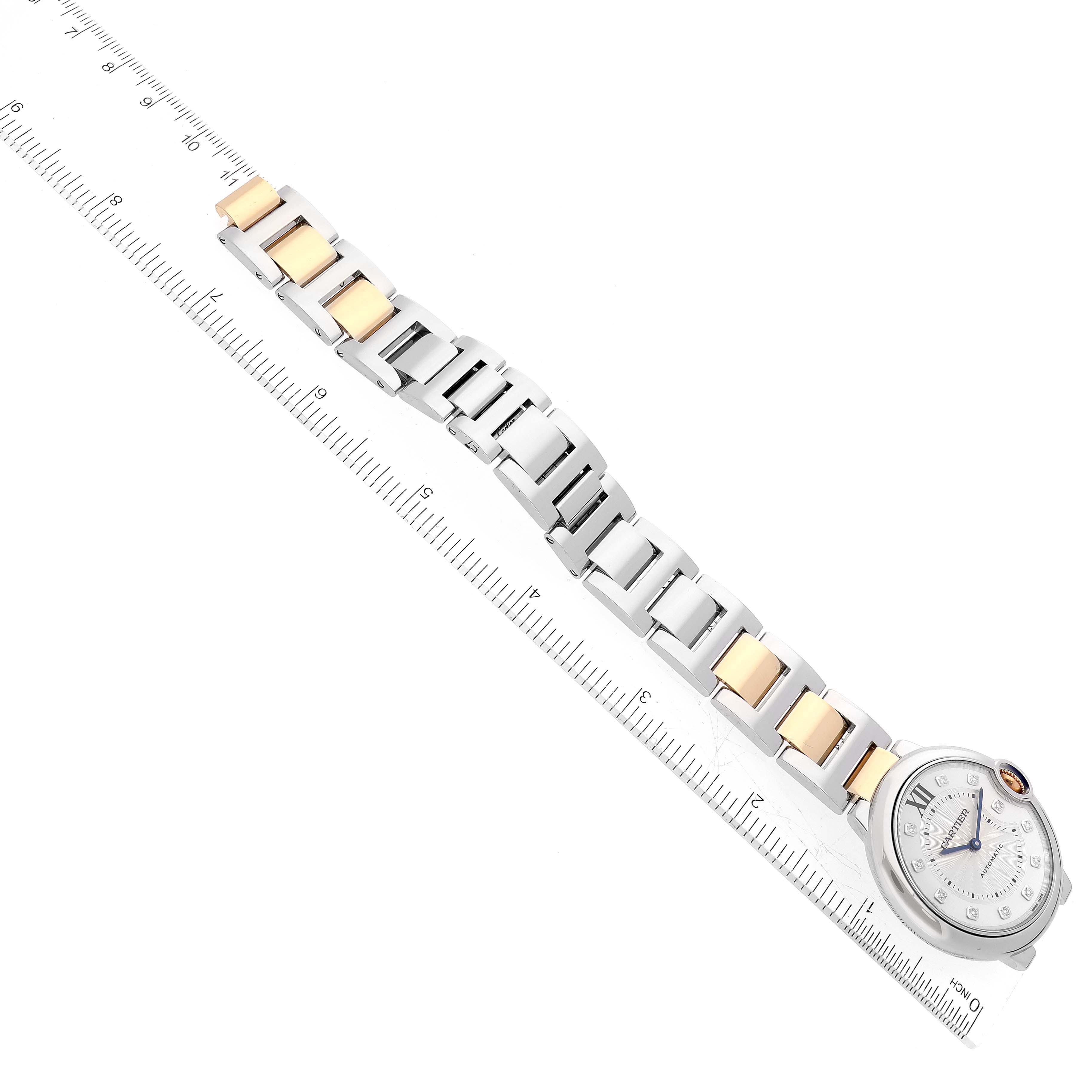 The Cartier Ballon Bleu W3BB0018 Women's Steel and Gold (two tone) Silver Dial W3BB0018 Women's Steel and Gold (two tone) Silver Dial watch is shown at a top-down angle, displaying the watch face and the metal bracelet with ruler for scale.