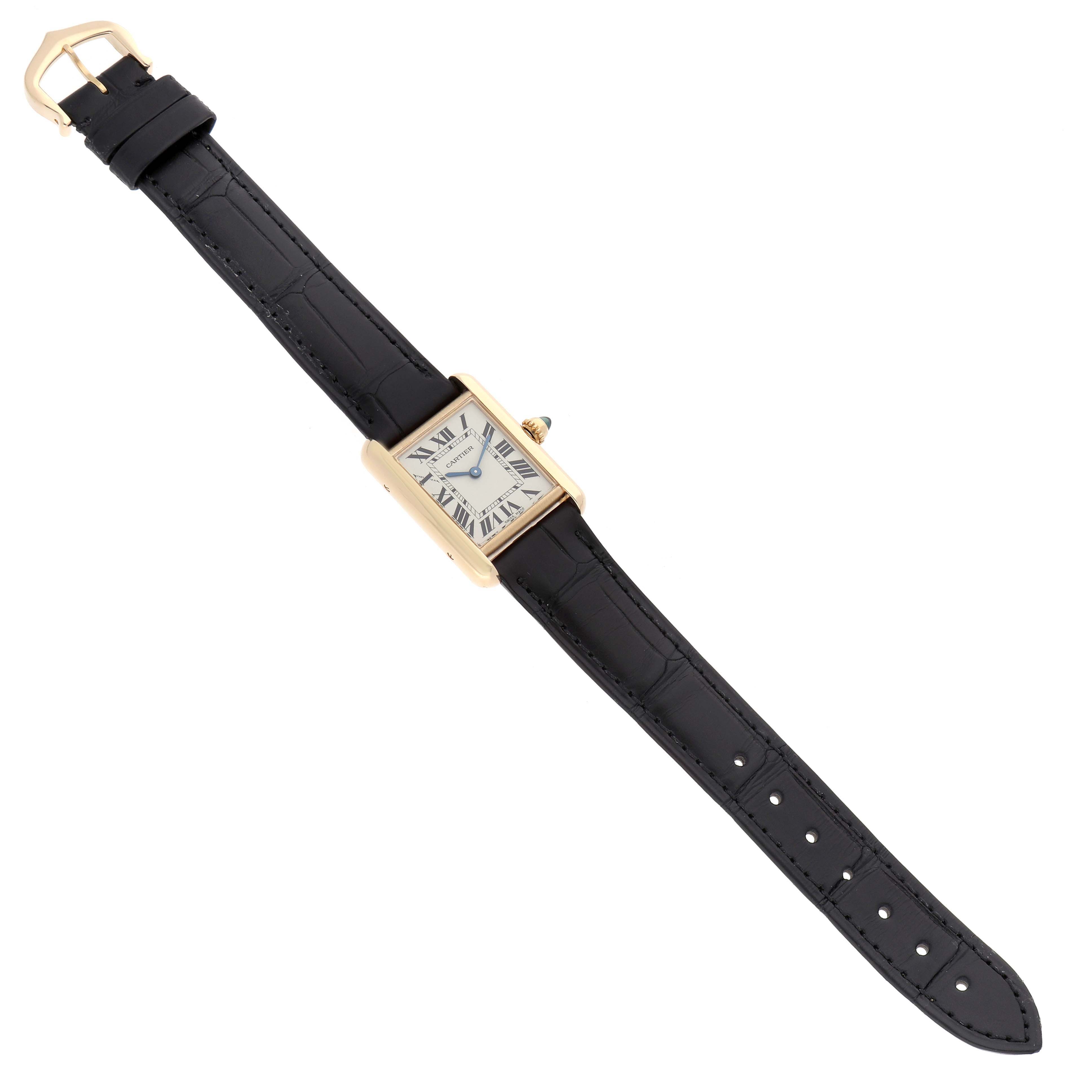 The Cartier Tank Louis W1529856 Women's Yellow Gold Silver Dial watch is shown from a top-down angle, displaying its rectangular face and black leather strap.