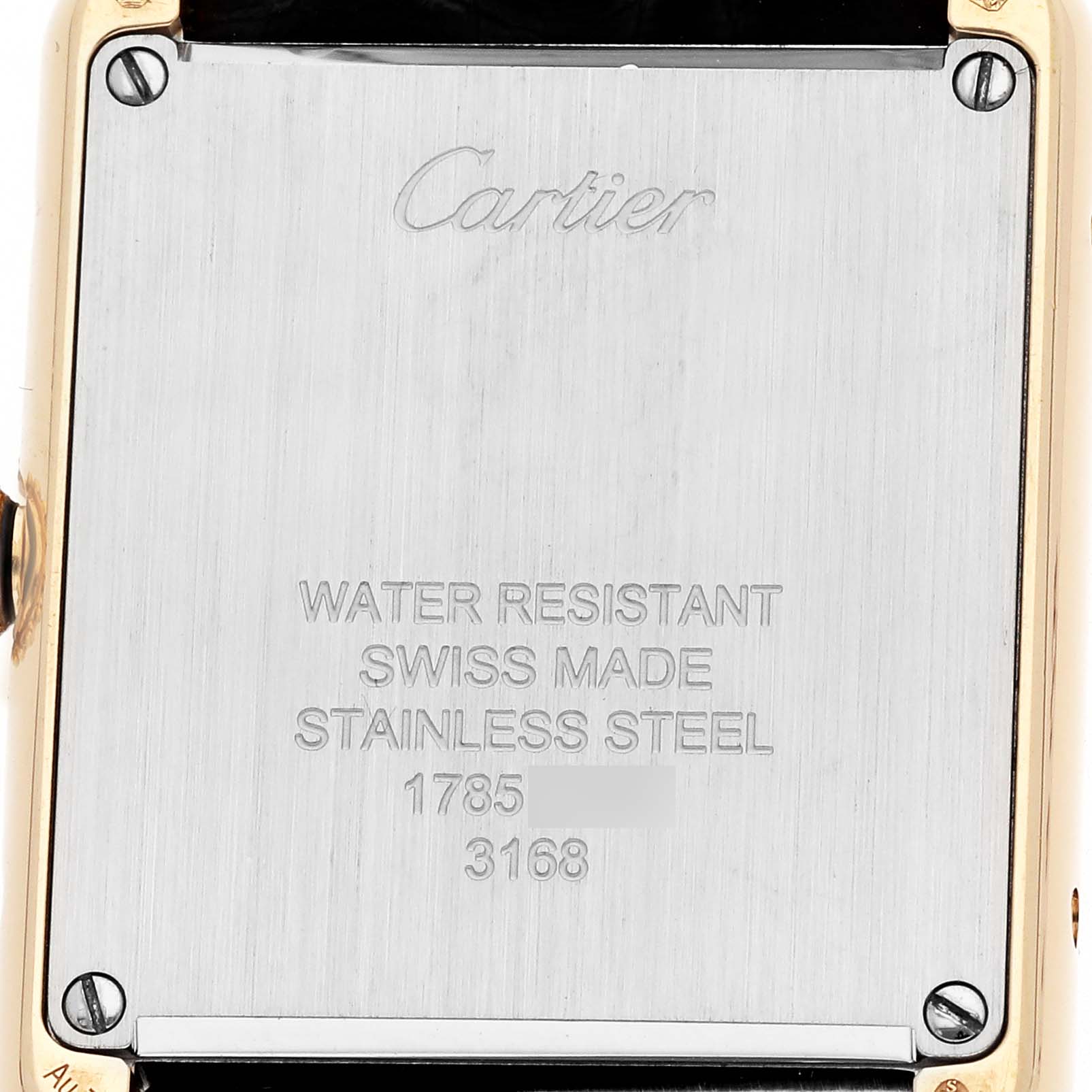 The image shows the back of a Cartier Tank Solo W5200002 Women's Yellow Gold Silver Dial watch, displaying engravings and screws.