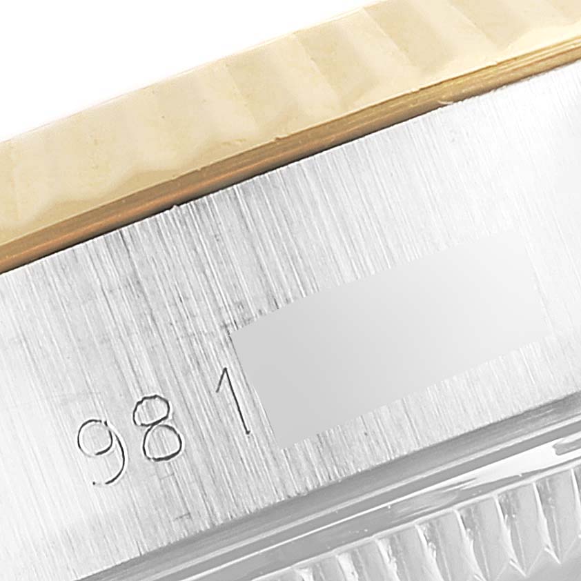 This close-up image of the Rolex Datejust 69173 Women
s Steel and Gold (two tone) Champagne Dial 69173 Women
s Steel and Gold (two tone) Champagne Dial watch shows part of the case and bezel, revealing a portion of the serial number.
