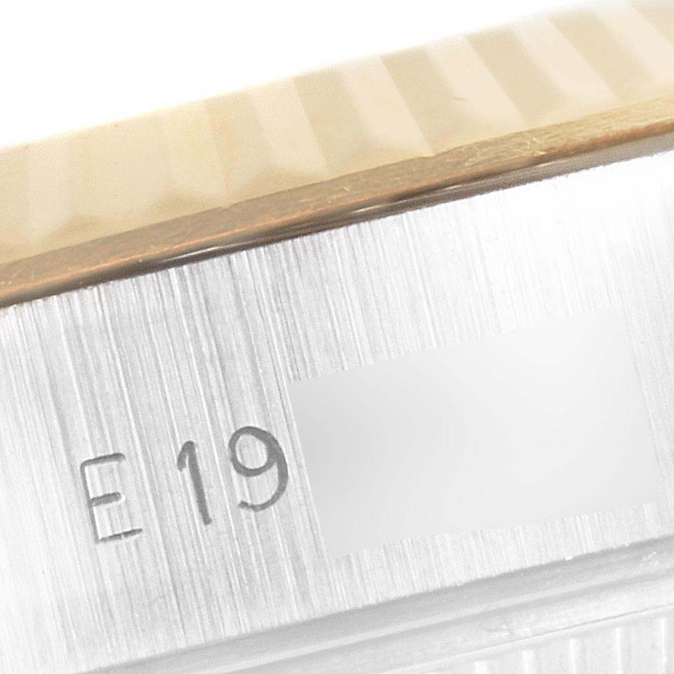 This image is a close-up of the side of a Rolex Datejust 69173 Women
s Steel and Gold (two tone) Champagne Dial 69173 Women
s Steel and Gold (two tone) Champagne Dial watch showing the serial number and part of the fluted bezel.