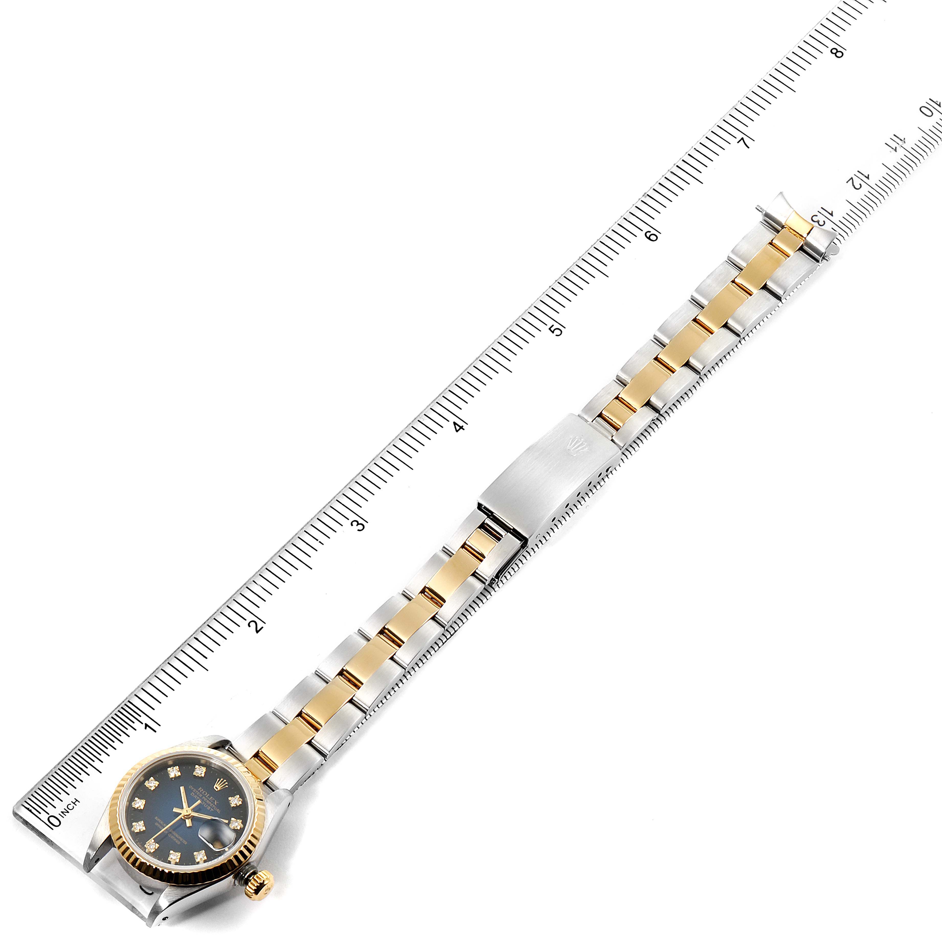 This is a top-down view of a Rolex Datejust 69173 Women's Steel and Gold (two tone) Blue Dial 69173 Women's Steel and Gold (two tone) Blue Dial watch, showcasing the dial, case, and metal bracelet beside a ruler for scale.
