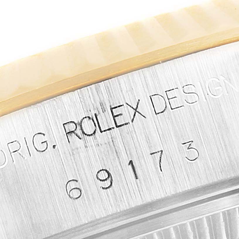 The image shows a close-up of the case side of a Rolex Datejust 69173 Women
s Steel and Gold (two tone) Champagne Dial 69173 Women
s Steel and Gold (two tone) Champagne Dial, highlighting the branding and part of the bezel.