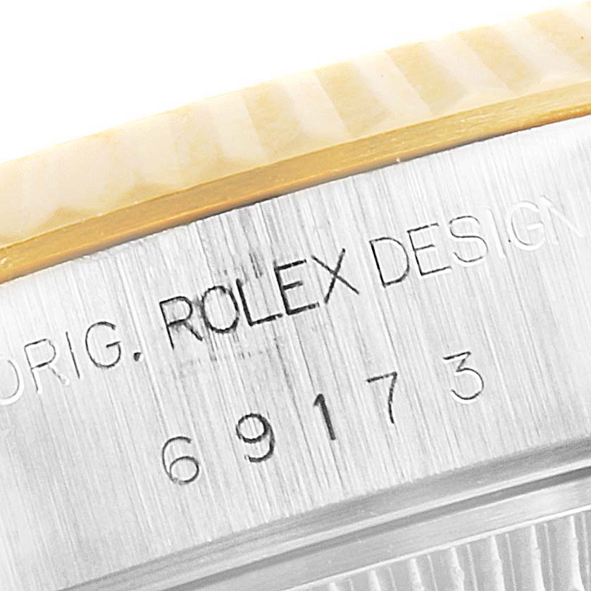 The image shows a close-up of the side of a Rolex Datejust 69173 Women
s Steel and Gold (two tone) Champagne Dial 69173 Women
s Steel and Gold (two tone) Champagne Dial watch case, featuring the model number and engraving.
