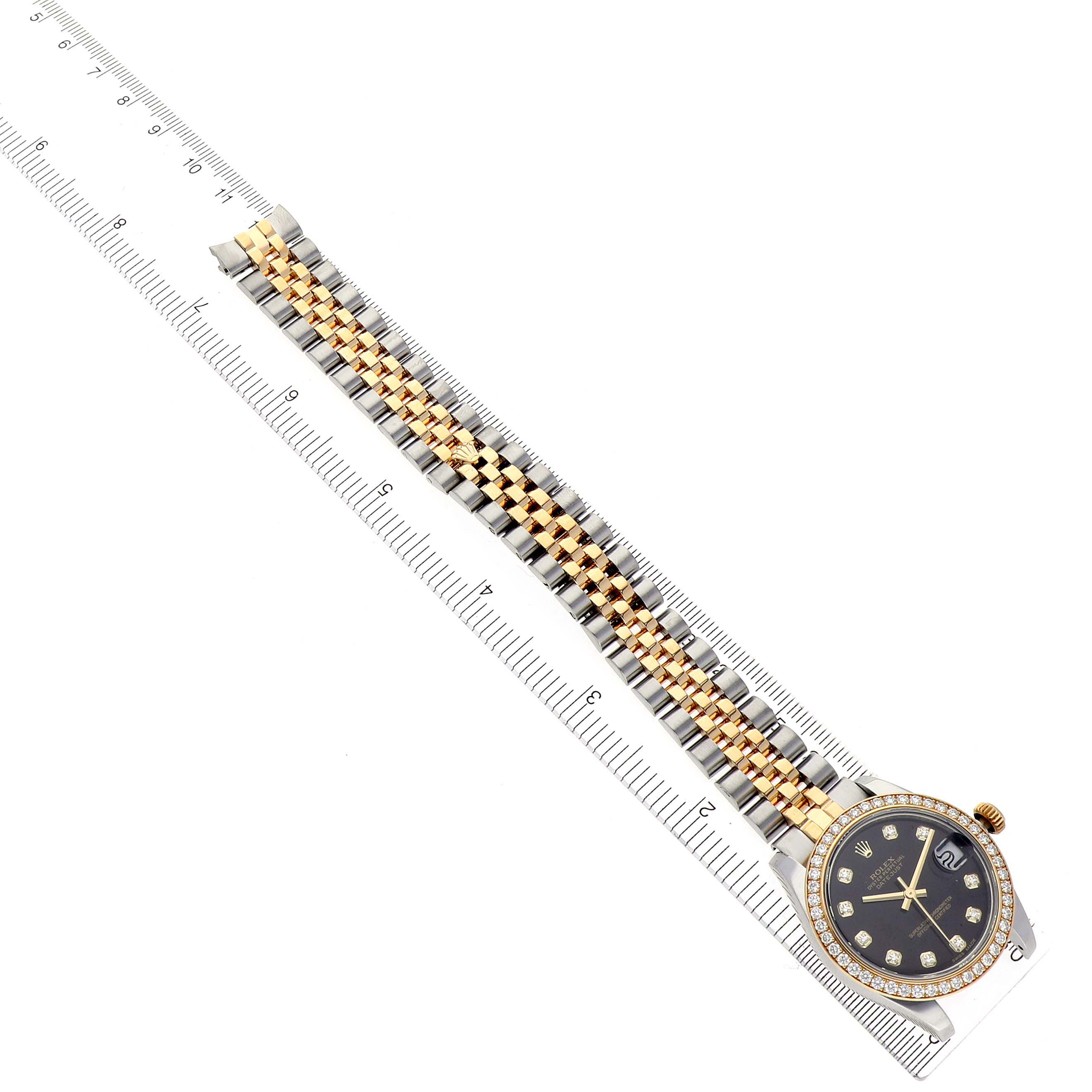 The Rolex Mid-Size 178383 Women's Steel and Gold (two tone) Black Dial 178383 Women's Steel and Gold (two tone) Black Dial watch is shown from the top, displaying the face and full bracelet against a ruler.