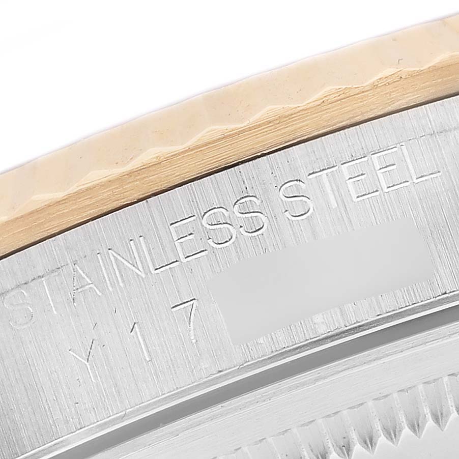 This image shows a close-up of the side engraving and fluted bezel of a Rolex Datejust 16233 Men's Steel and Gold (two tone) Blue Dial 16233 Men's Steel and Gold (two tone) Blue Dial watch.