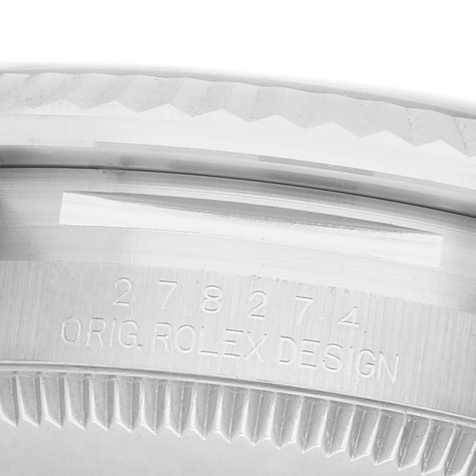 The image shows a close-up of the side view of a Rolex Mid-Size 278274 Women's Stainless Steel Black Dial model watch, highlighting the bezel and engraved design.
