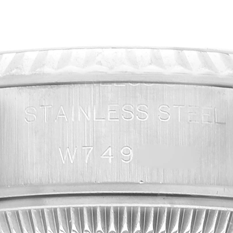 The image shows an extreme close-up of the case side and fluted bezel of a Rolex Datejust 69174 Women's Stainless Steel Blue Dial 69174 Women's Stainless Steel Blue Dial watch, highlighting the stainless steel inscription.