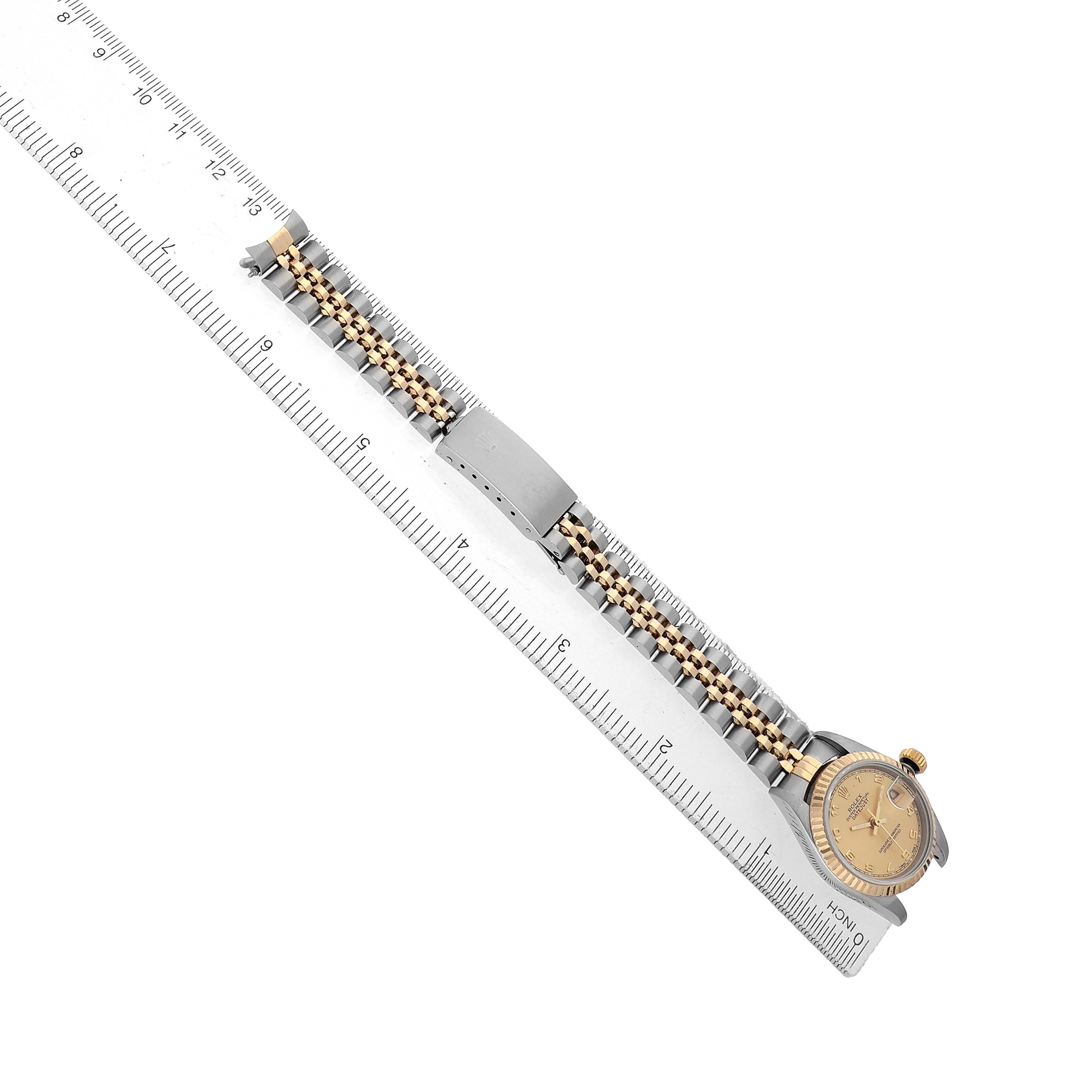 The image shows a top view of a Rolex Datejust 69173 Women's Steel and Gold (two tone) Champagne Dial watch with a gold and silver bracelet laid alongside a ruler.