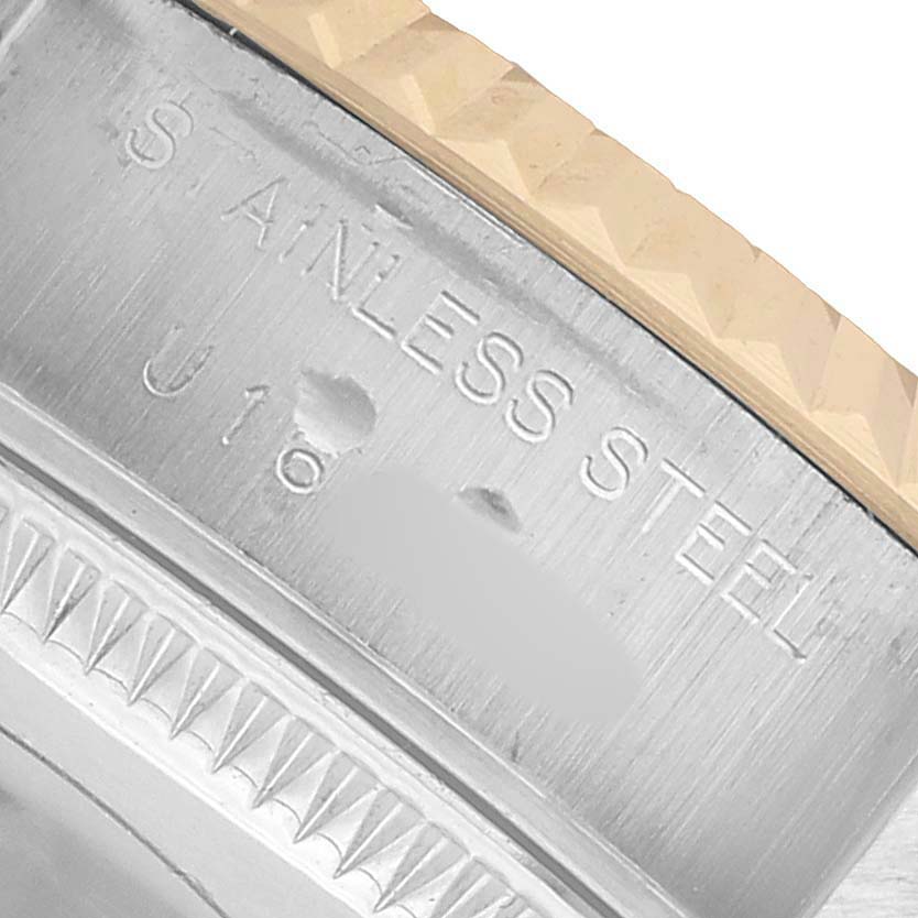 The image shows the side angle of the Rolex Datejust 69173 Women's Steel and Gold (two tone) Champagne Dial watch's stainless steel case, featuring engravings and part of the bezel.