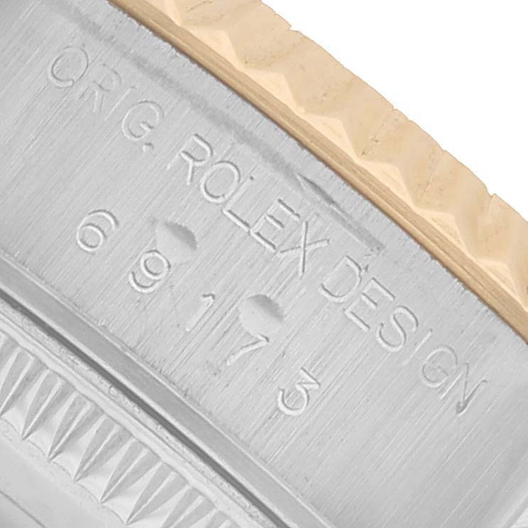 The image shows a close-up of the side of a Rolex Datejust 69173 Women's Steel and Gold (two tone) Champagne Dial, featuring its engraved bezel and model number.