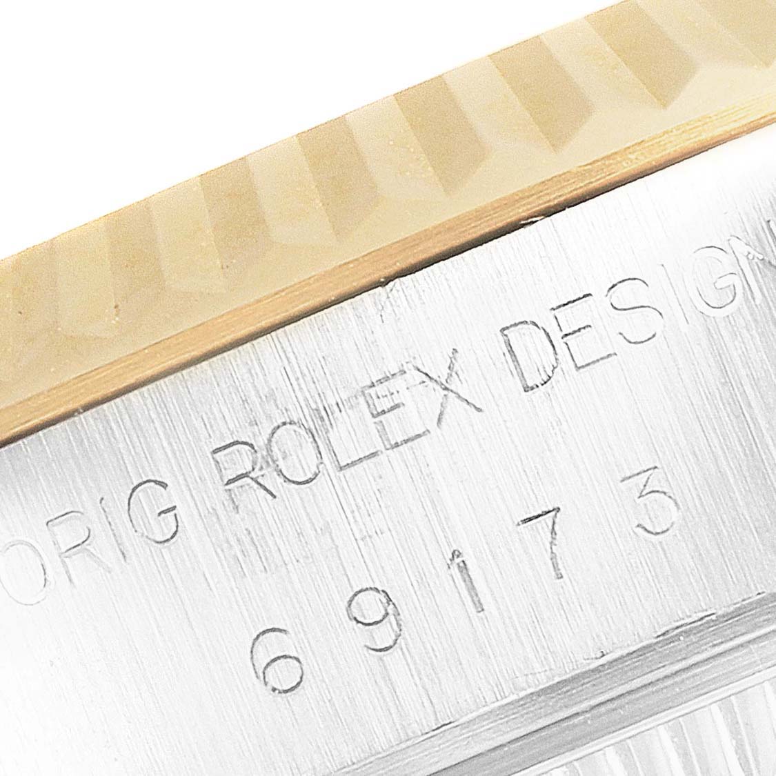 Close-up of a Rolex Datejust 69173 Women's Steel and Gold (two tone) Champagne Dial 69173 Women's Steel and Gold (two tone) Champagne Dial watch bezel and case engraving, showing the model number and part of the design text.