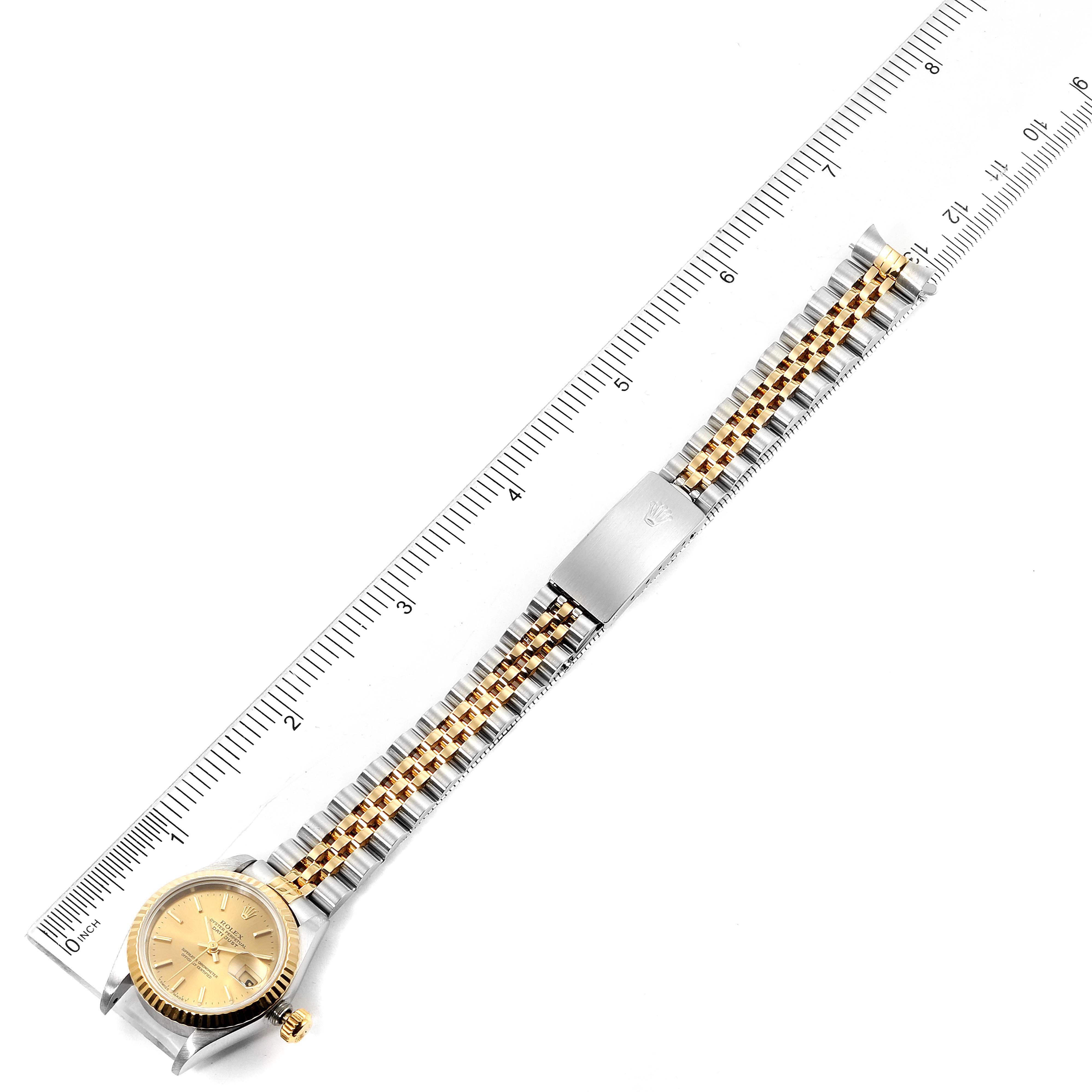 The Rolex Datejust 69173 Women's Steel and Gold (two tone) Champagne Dial 69173 Women's Steel and Gold (two tone) Champagne Dial watch is shown laid flat, highlighting the face, bezel, and bracelet, along with measurements marked on a ruler.