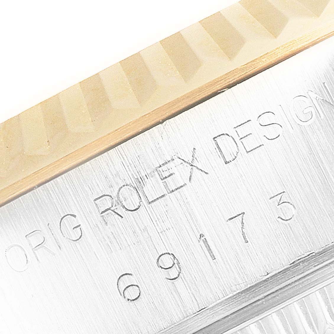 This close-up image shows the edge of the bezel and part of the casing with the engraving on a Rolex Datejust 69173 Women
s Steel and Gold (two tone) Champagne Dial 69173 Women
s Steel and Gold (two tone) Champagne Dial watch.