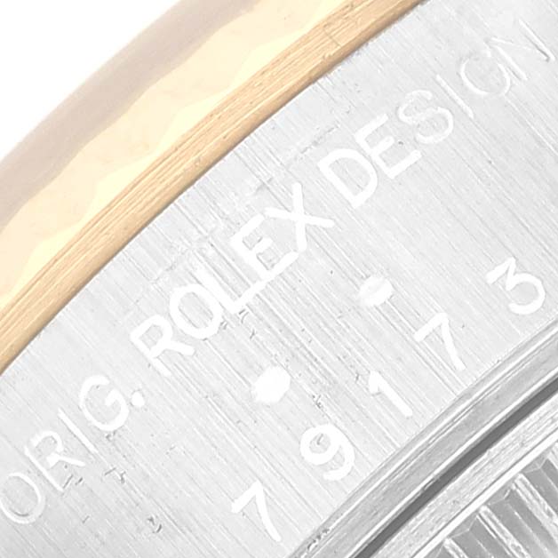 This image shows a close-up of the side of a Rolex Datejust 79173 Women's Steel and Gold (two tone) White Dial 79173 Women's Steel and Gold (two tone) White Dial watch, highlighting the engraved text on the metal casing.