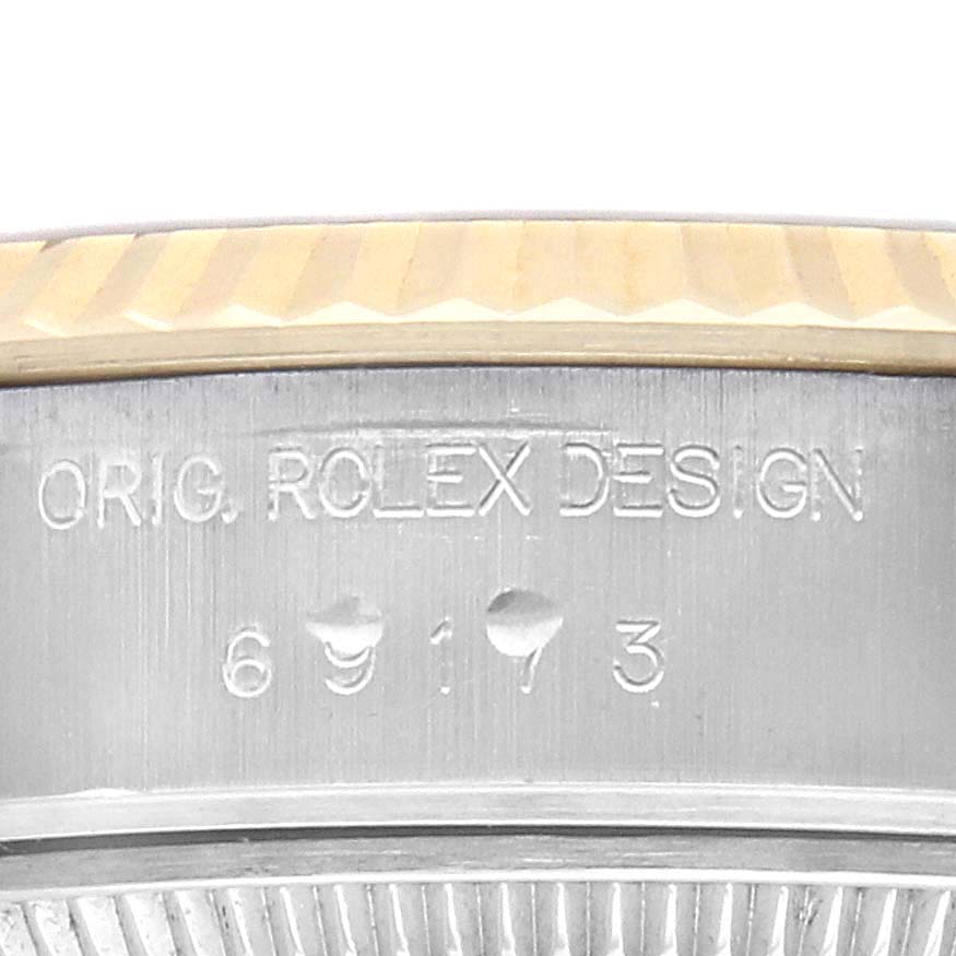 The image shows a close-up of the case side featuring engraved text on a Rolex Datejust 69173 Women's Steel and Gold (two tone) Champagne Dial watch.