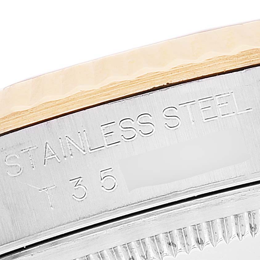 This image shows a close-up of the stainless steel side and fluted bezel of a Rolex Datejust 16233 Men's Steel and Gold (two tone) Silver Dial 16233 Men's Steel and Gold (two tone) Silver Dial watch.