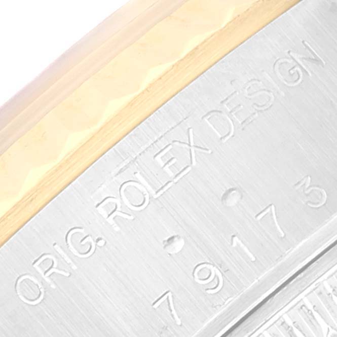 The image shows a close-up of the side of a Rolex Datejust 79173 Women's Steel and Gold (two tone) Grey Dial 79173 Women's Steel and Gold (two tone) Grey Dial, featuring engravings.