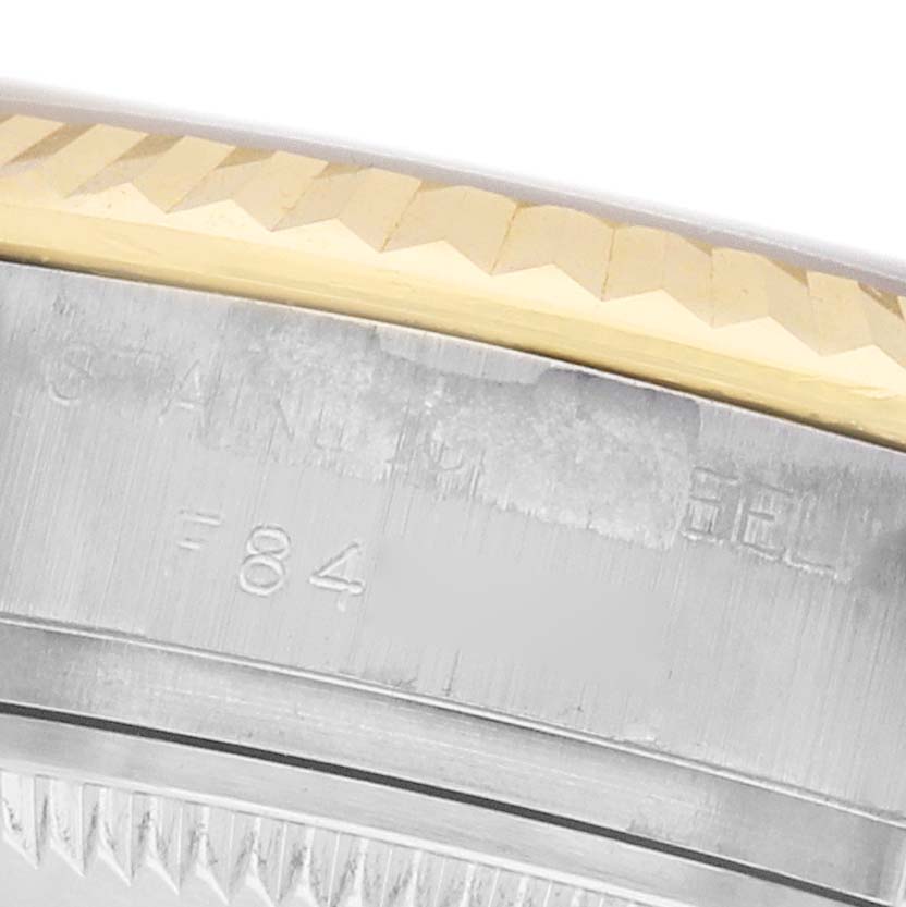 The image shows a close-up of the side of a Rolex Datejust 179173 Women's Stainless Steel White Dial watch, focusing on the fluted bezel and engraved edge.