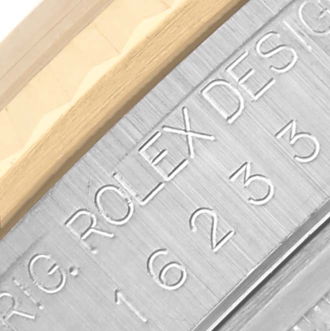 The image shows a close-up of the engraved side and partial bezel of a Rolex Datejust 16233 Men's Steel and Gold (two tone) Blue Dial 16233 Men's Steel and Gold (two tone) Blue Dial.