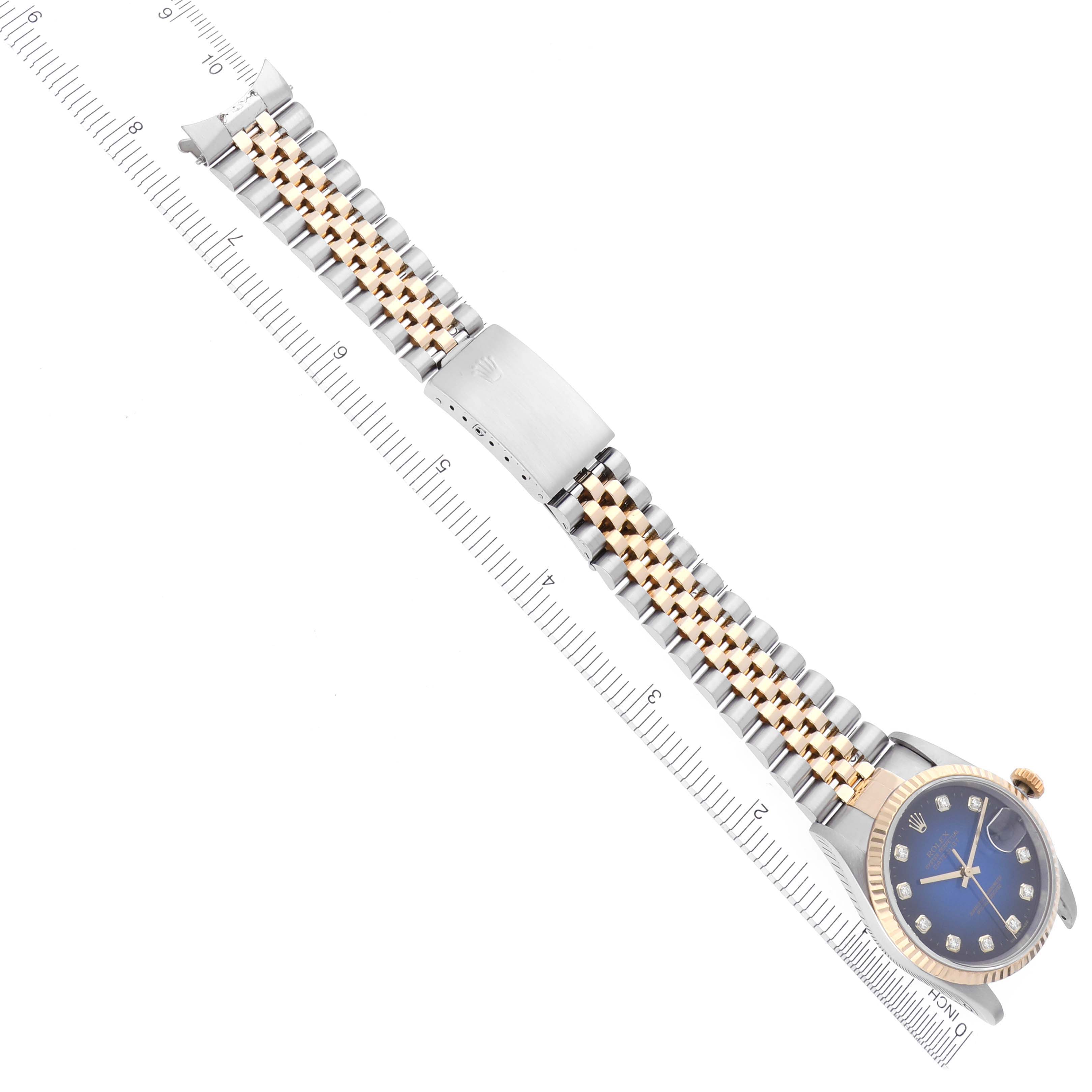 The Rolex Datejust 16233 Men's Steel and Gold (two tone) Blue Dial 16233 Men's Steel and Gold (two tone) Blue Dial watch is shown from a top view, displaying the face, crown, bracelet, and clasp, alongside a ruler for scale.