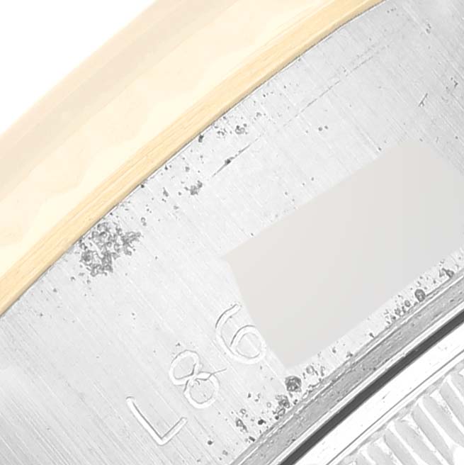 This close-up image shows the case side of a Rolex Datejust 69173 Women's Steel and Gold (two tone) White Dial 69173 Women's Steel and Gold (two tone) White Dial watch, including engraved text and part of the bezel.