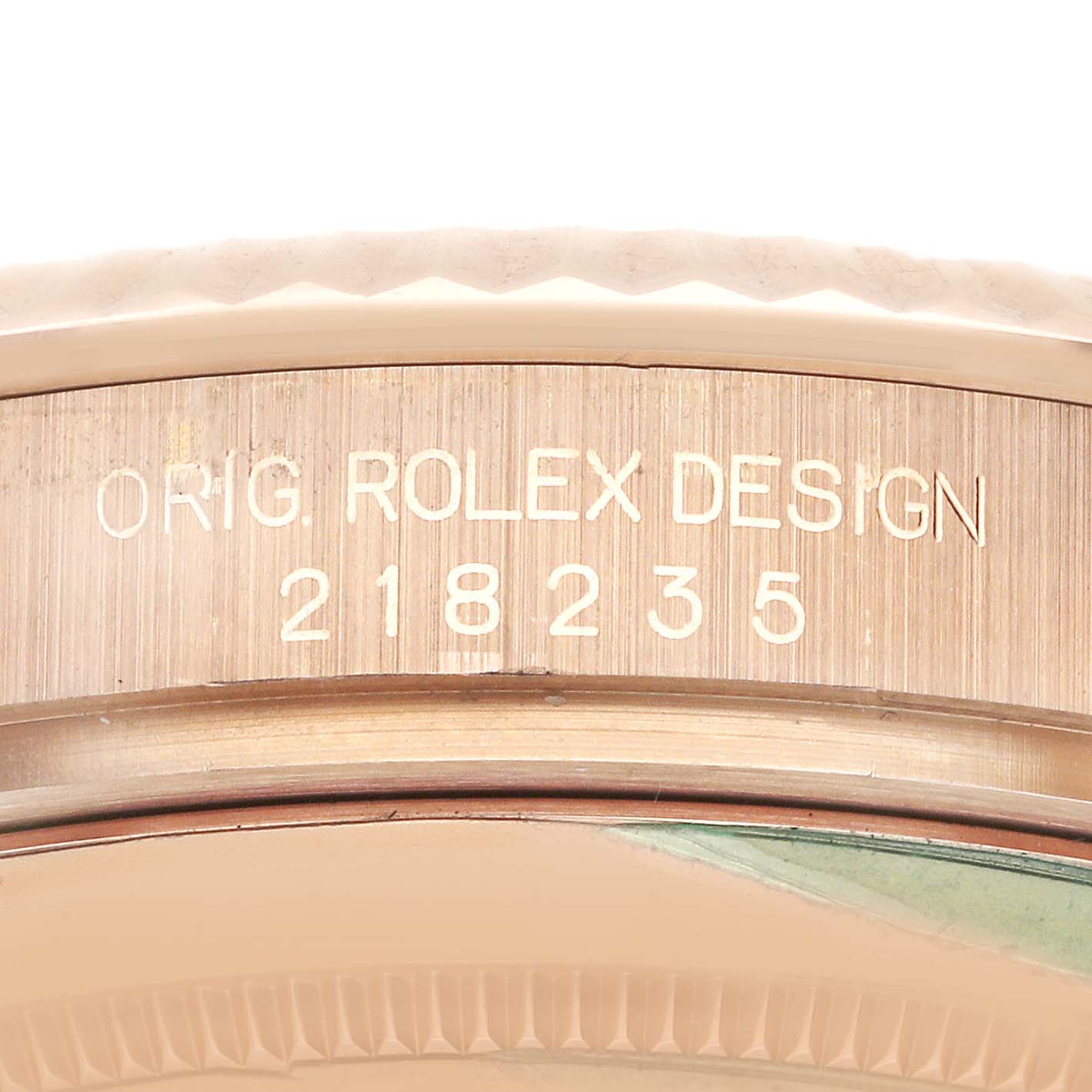 The image shows a close-up side angle of a Rolex President 218235 Men's Rose Gold Brown Dial 218235 Men's Rose Gold Brown Dial watch, highlighting the engraved reference number and bezel edge.