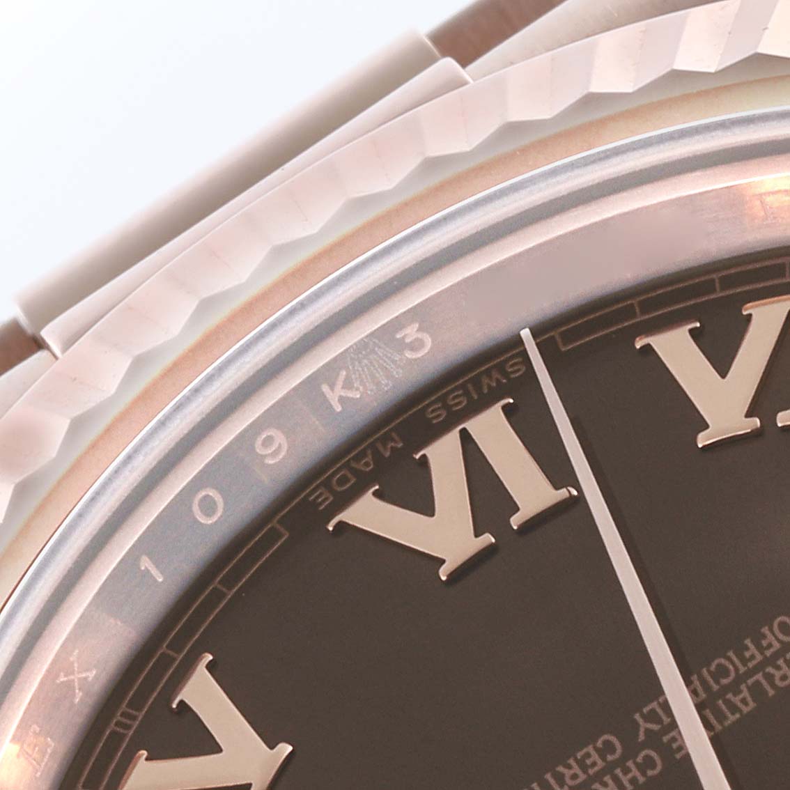 The image shows a close-up of the bezel, partial dial, and Roman numerals on a Rolex President 218235 Men's Rose Gold Brown Dial 218235 Men's Rose Gold Brown Dial model watch.
