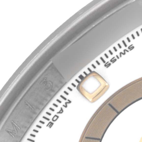 This image shows a close-up of the Rolex Daytona 116523 Men's Steel and Gold (two tone) White Dial 116523 Men's Steel and Gold (two tone) White Dial's bezel and dial, including the "Swiss Made" text and part of an hour marker.