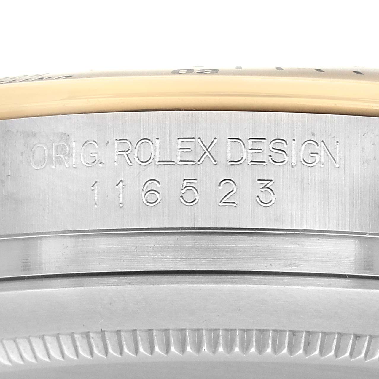 The image shows a close-up of the side of a Rolex Daytona 116523 Men's Steel and Gold (two tone) White Dial, featuring the engraved model number "116523".