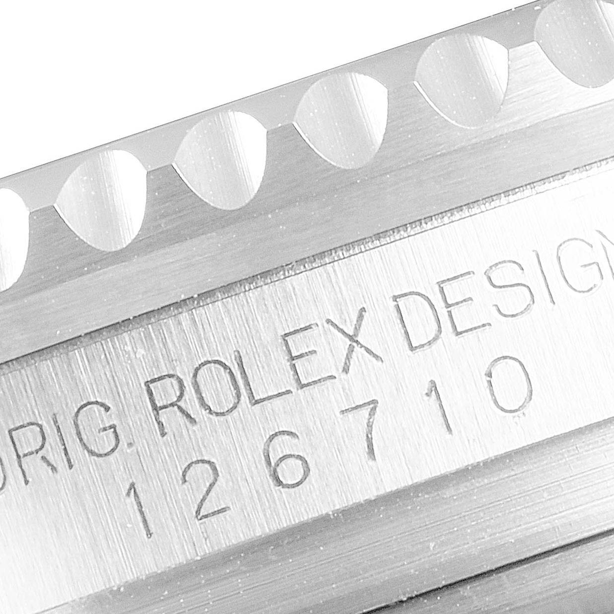 This close-up image of the Rolex GMT-Master 126710 Men's Stainless Steel Black Dial 126710 Men's Stainless Steel Black Dial watch shows the engraved model number and part of the textured bezel.