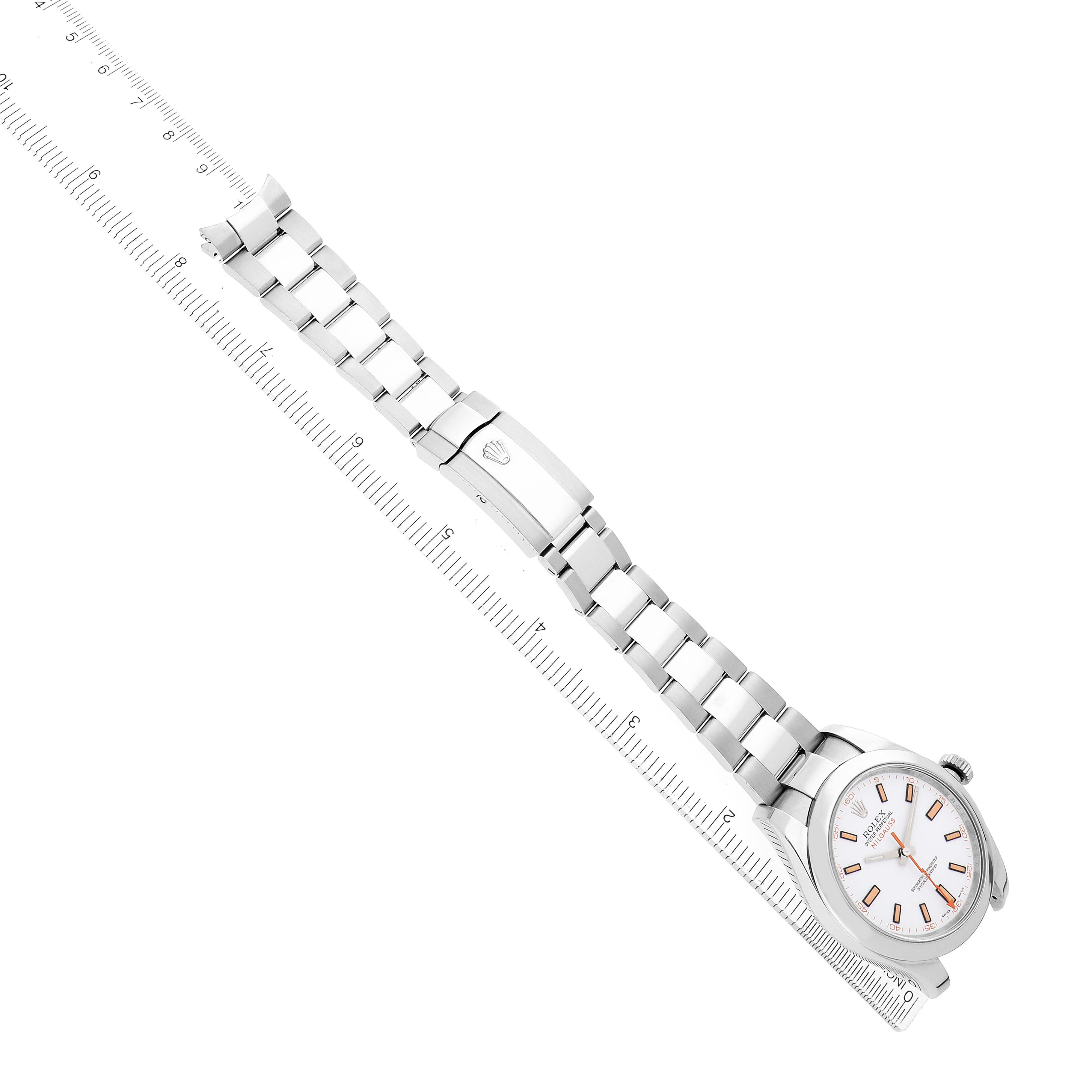 The Rolex Milgauss 116400 Men's Stainless Steel White Dial watch is shown from an angled top view, displaying the face, bracelet, and clasp alongside a ruler.
