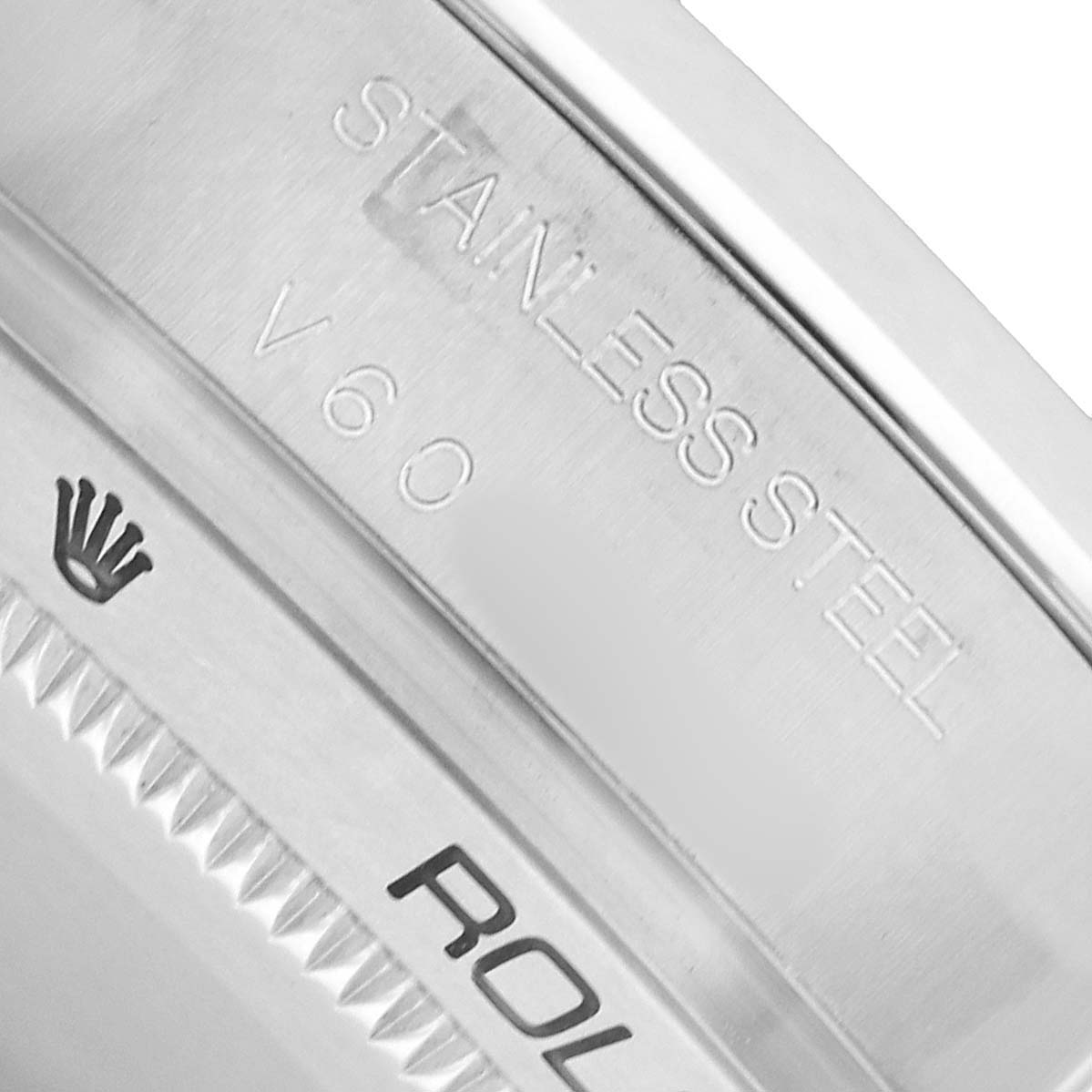The image shows an angled close-up of the stainless steel case back of a Rolex Milgauss 116400 Men's Stainless Steel White Dial, featuring the brand logo and inscriptions.
