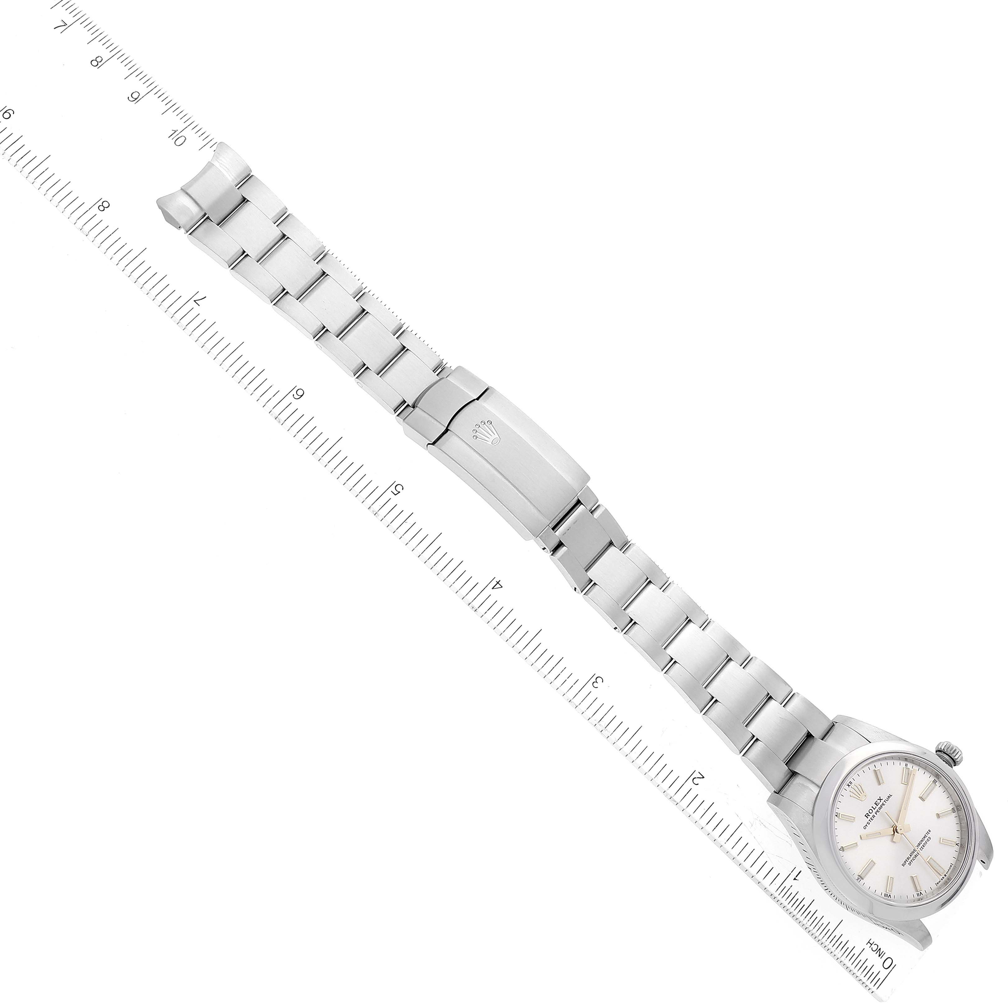 This image shows a top-down view of a Rolex Oyster Perpetual 124200 Men's Stainless Steel Silver Dial 124200 Men's Stainless Steel Silver Dial watch, highlighting the face and bracelet with extended clasp next to a ruler.