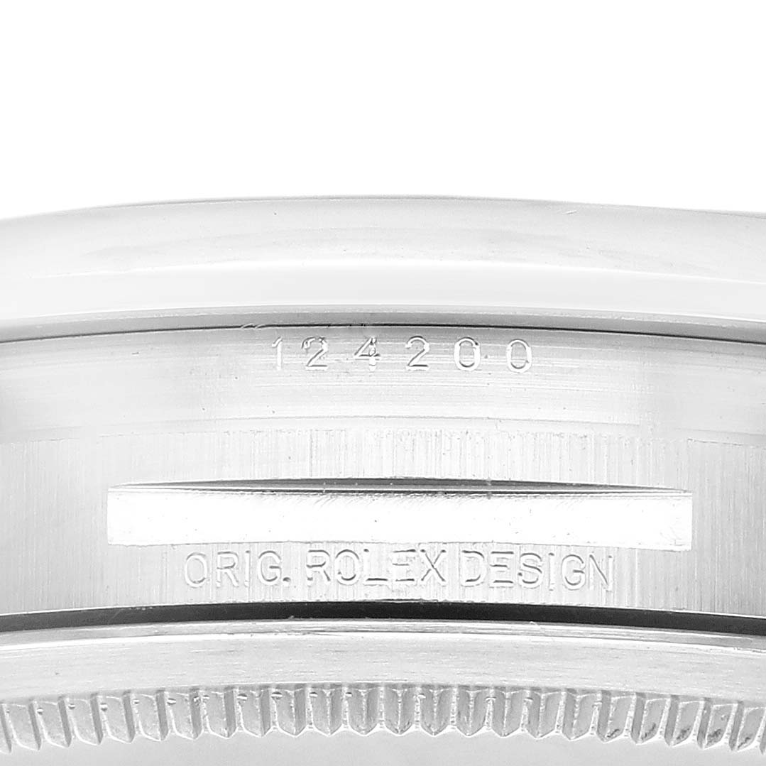 This image shows a close-up view of the case side of a Rolex Oyster Perpetual 124200 Men's Stainless Steel Silver Dial 124200 Men's Stainless Steel Silver Dial model, featuring the serial number and "ORIG. ROLEX DESIGN" engraving.
