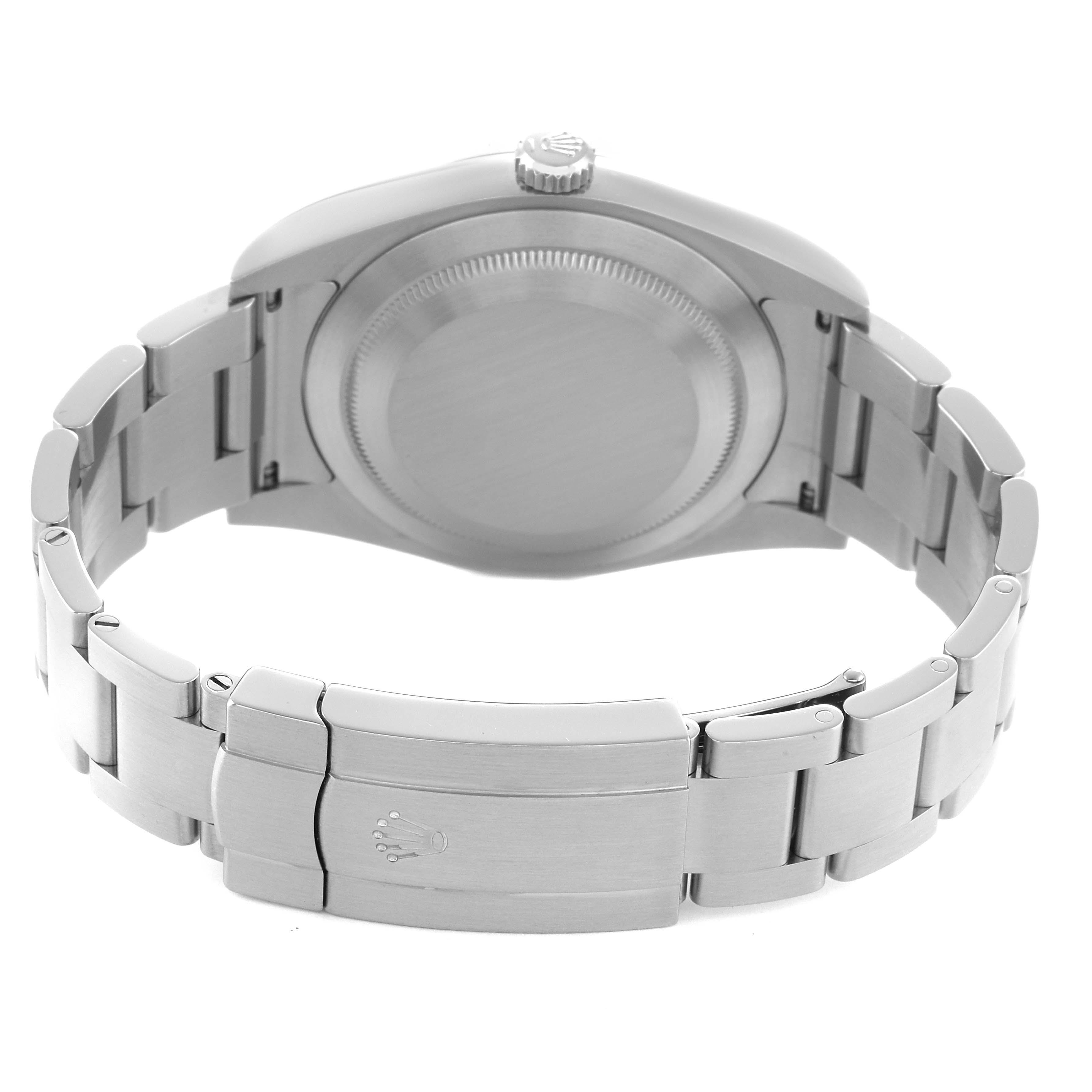 The image shows the back view of a Rolex Oyster Perpetual 114300 Men's Stainless Steel Silver Dial, highlighting the case back, crown, and metallic bracelet with clasp.
