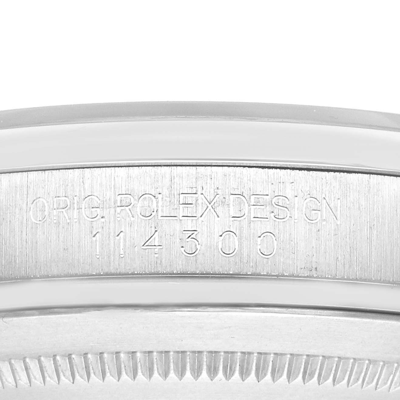The image shows the side of a Rolex Oyster Perpetual 114300 Men's Stainless Steel Silver Dial watch case with model number engraving.